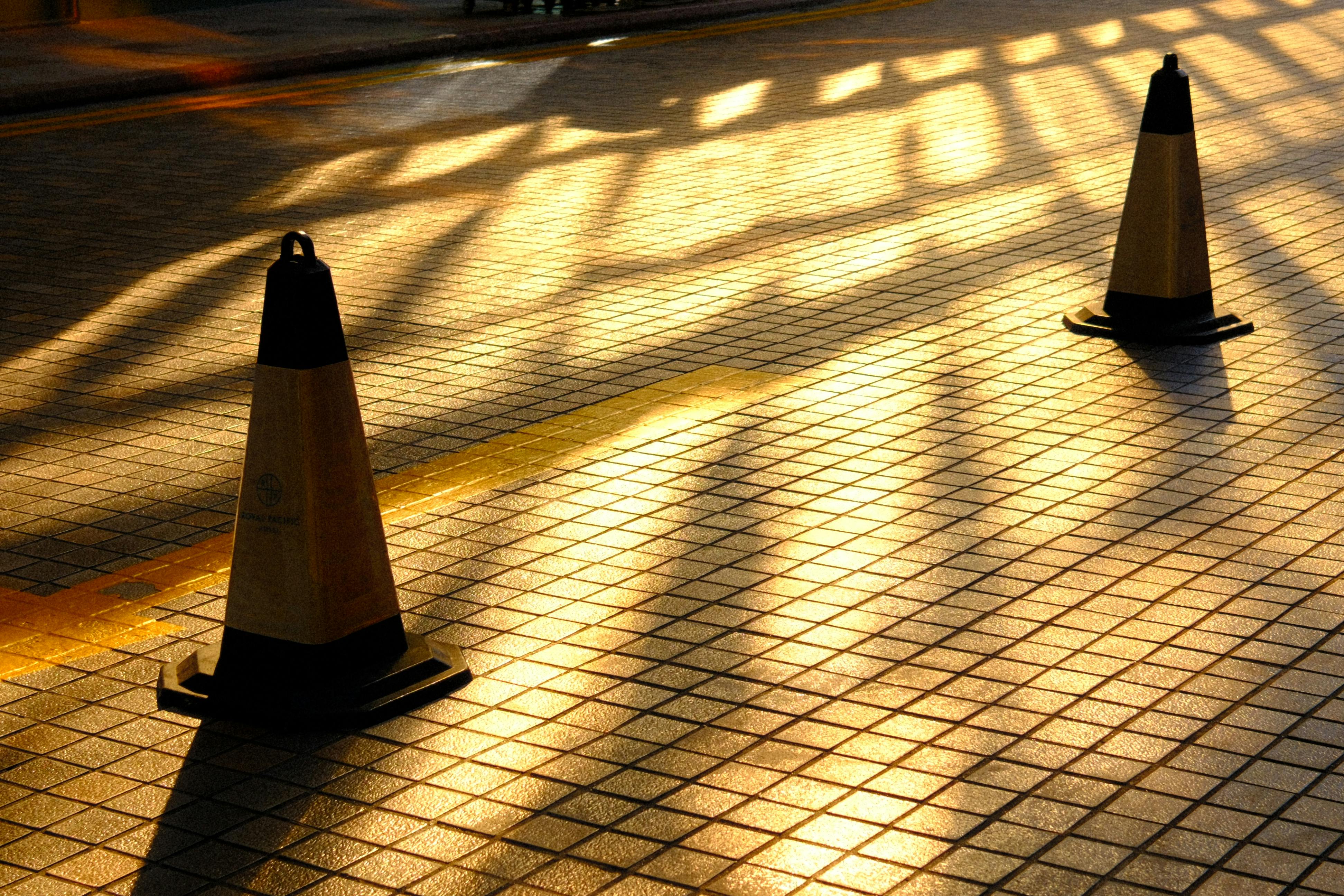 ingyenes Két közlekedési bója árnyékot vet a napsütötte csempézett járdára Hongkongban. Stockfotó