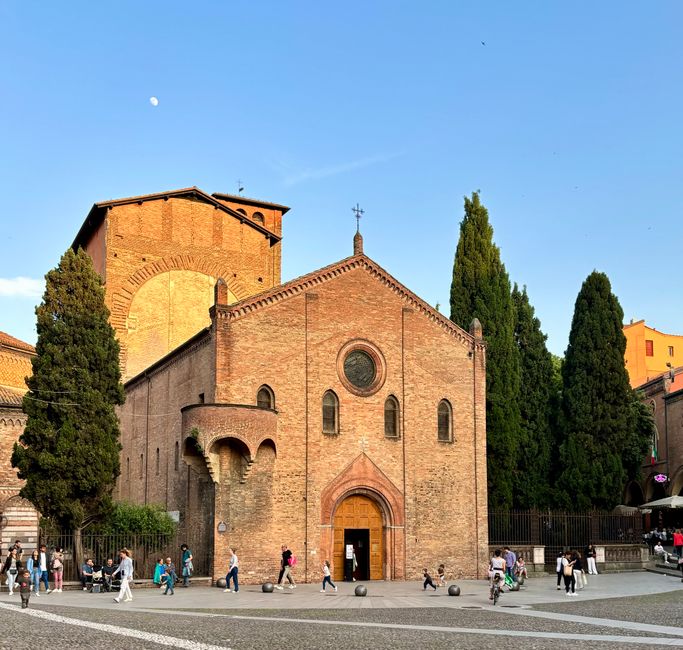The historic Basilica of Santo Stefano in Bologna, Italy, captured during a vibrant and lively evening.