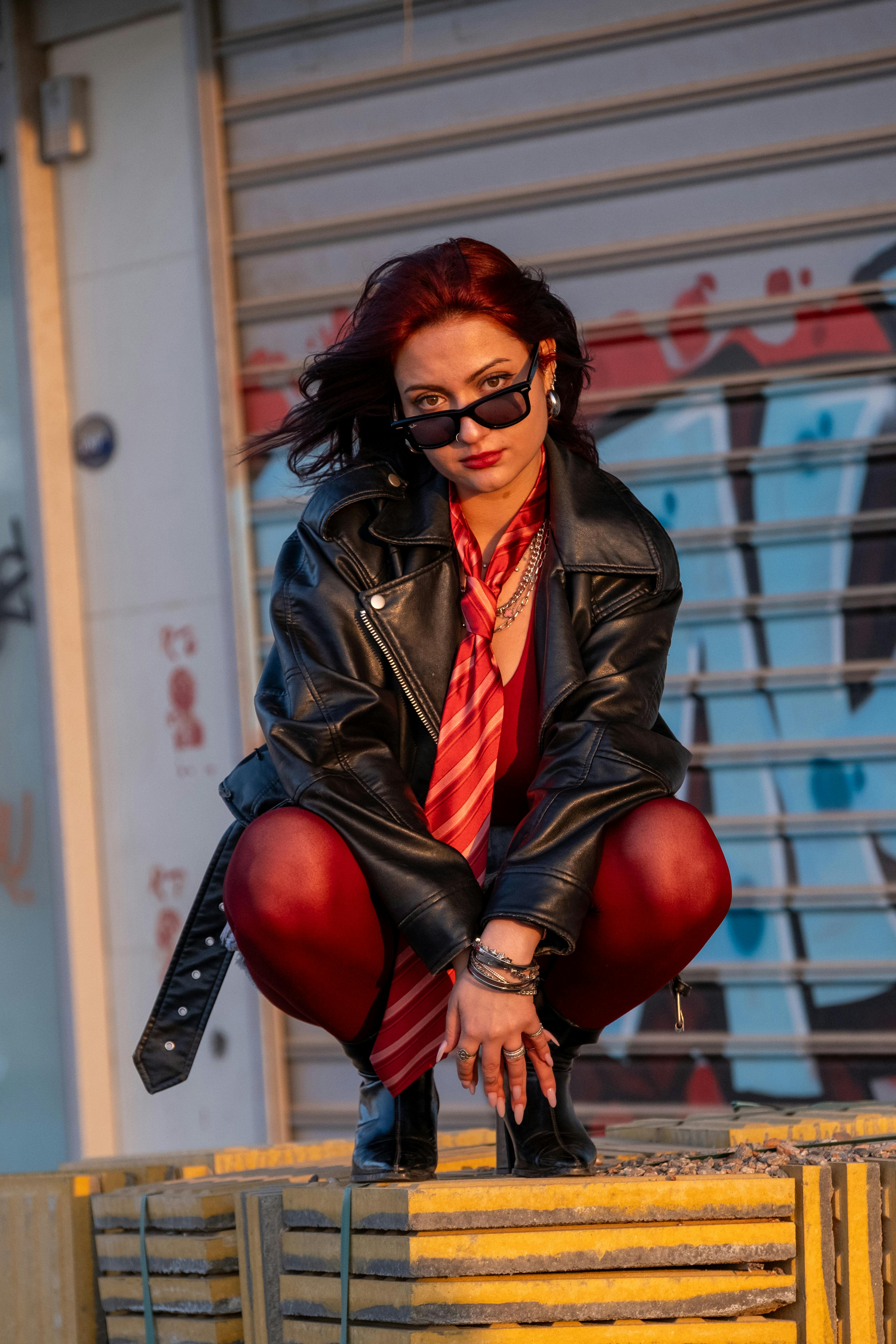 bezplatná Stylová žena v kožené bundě sebevědomě pózuje v městském prostředí. Základová fotografie