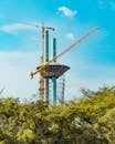 Tower Construction with Cranes Against Blue Sky