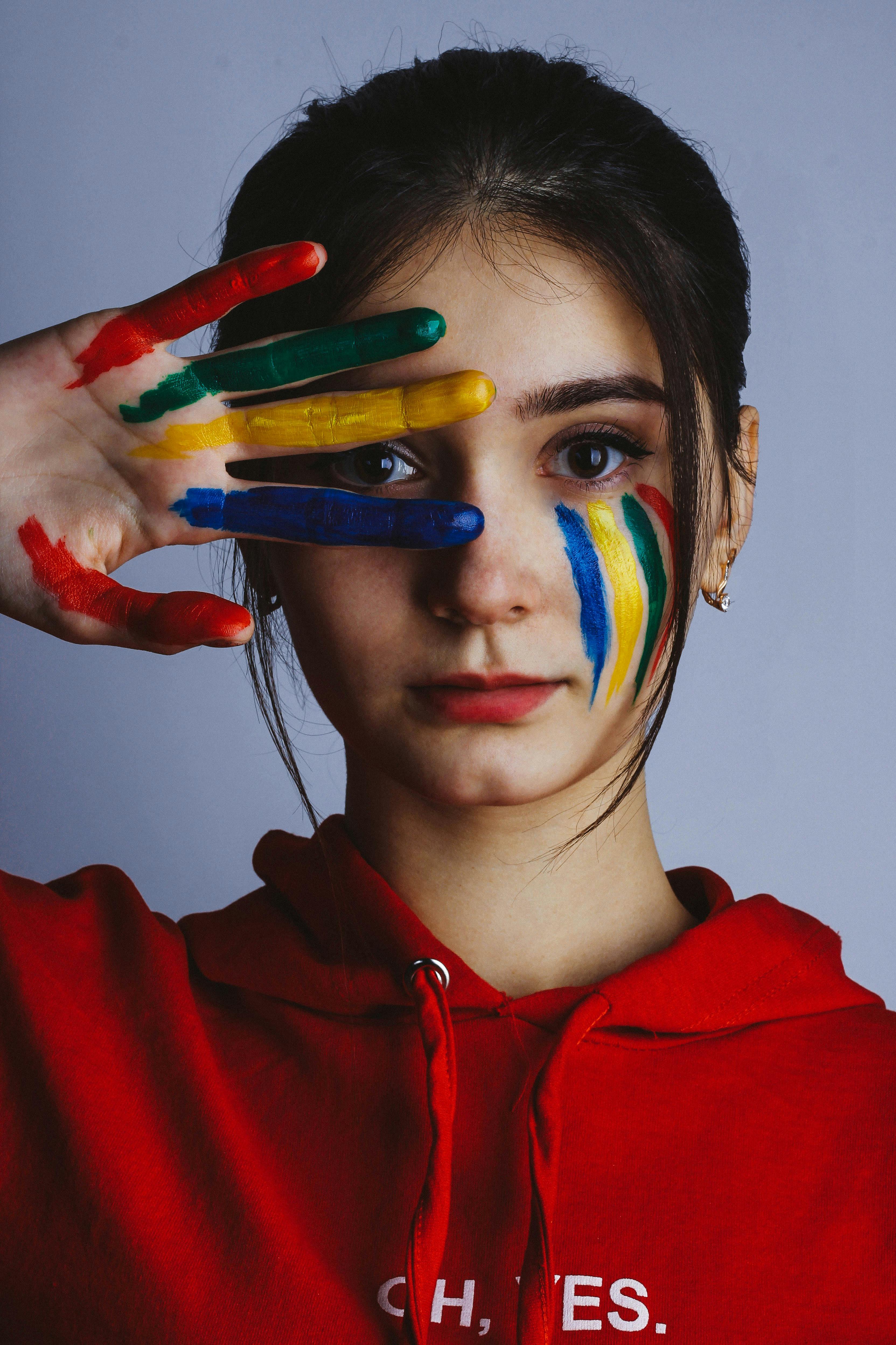 Woman In Red Hoodie Jacket With Blue Yellow And Green Paint On