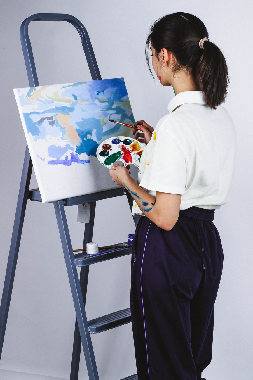 Artist finishing a canvas live with palette in hand