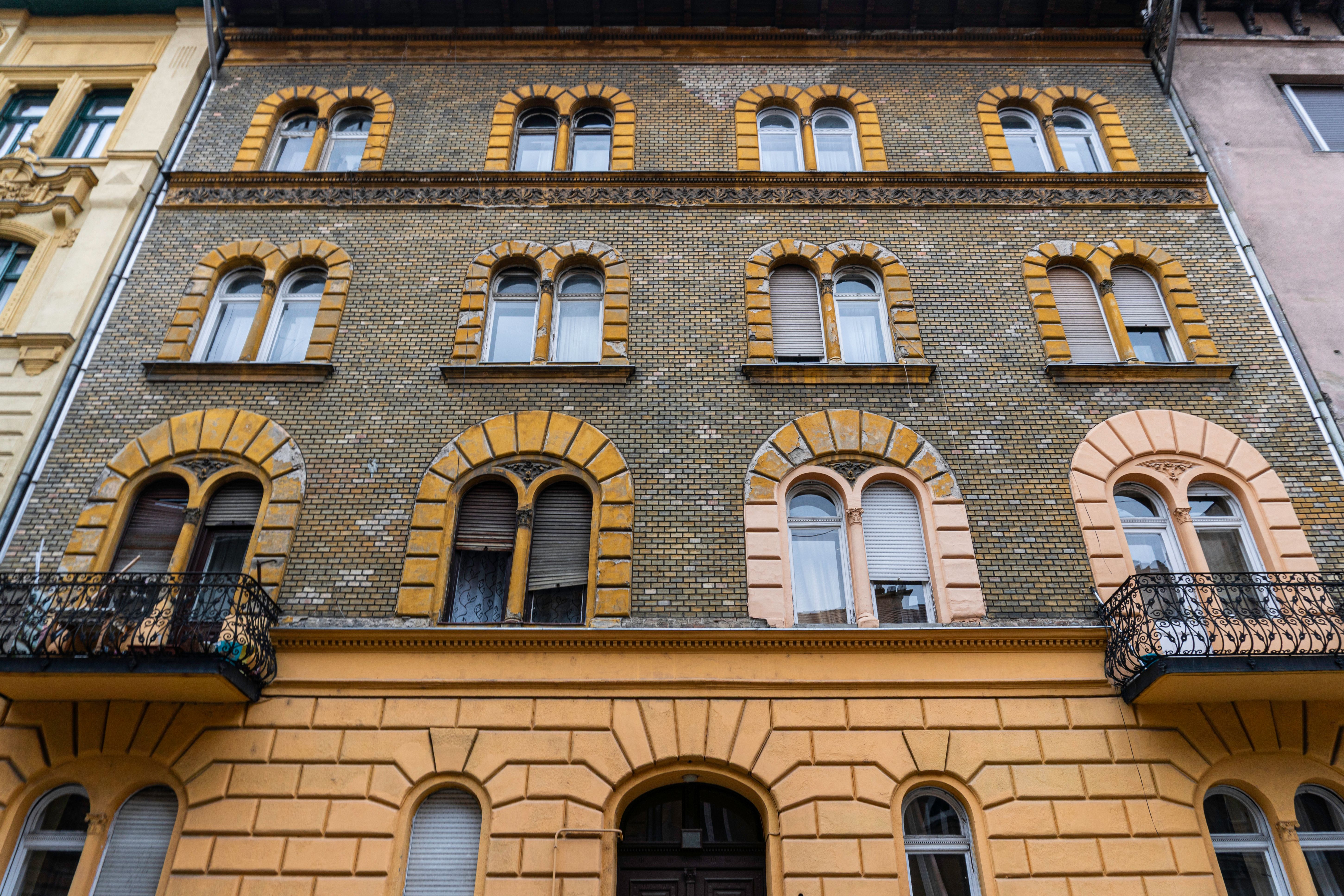 A detailed view of a classic European facade featuring arched windows and brickwork.