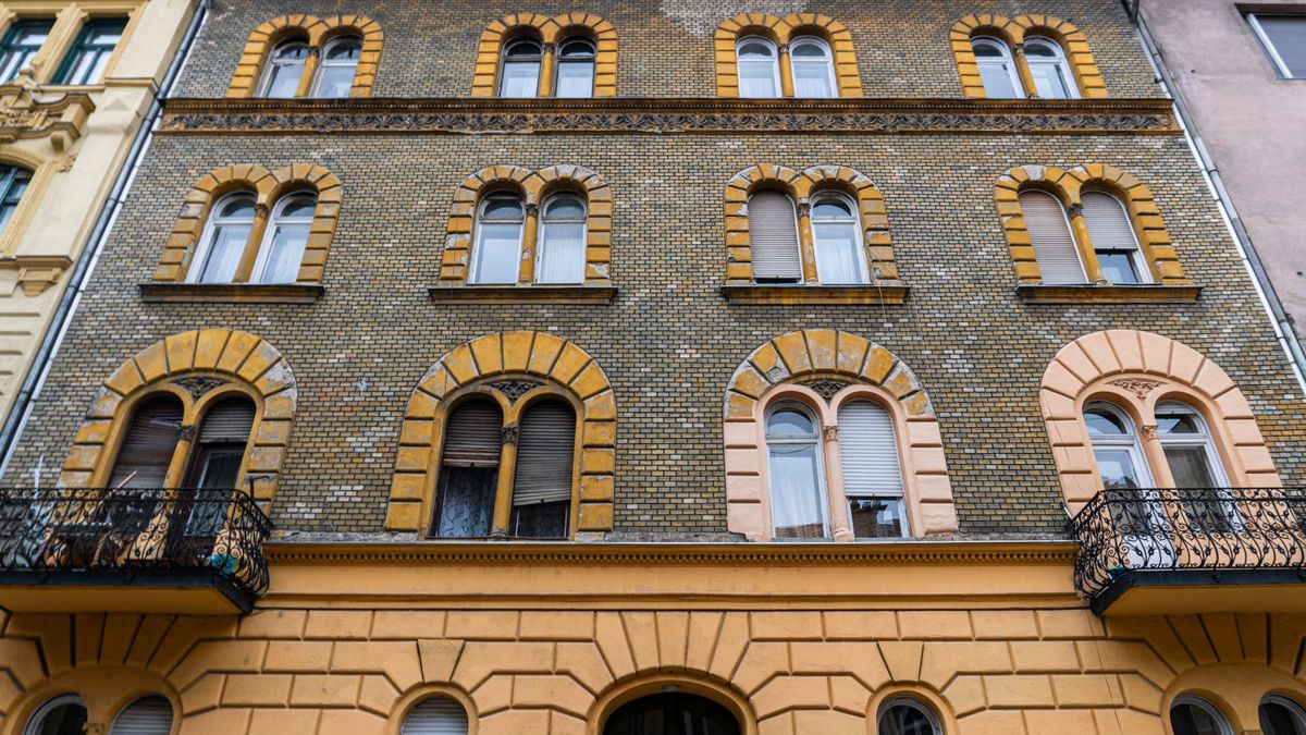 A detailed view of a classic European facade featuring arched windows and brickwork.