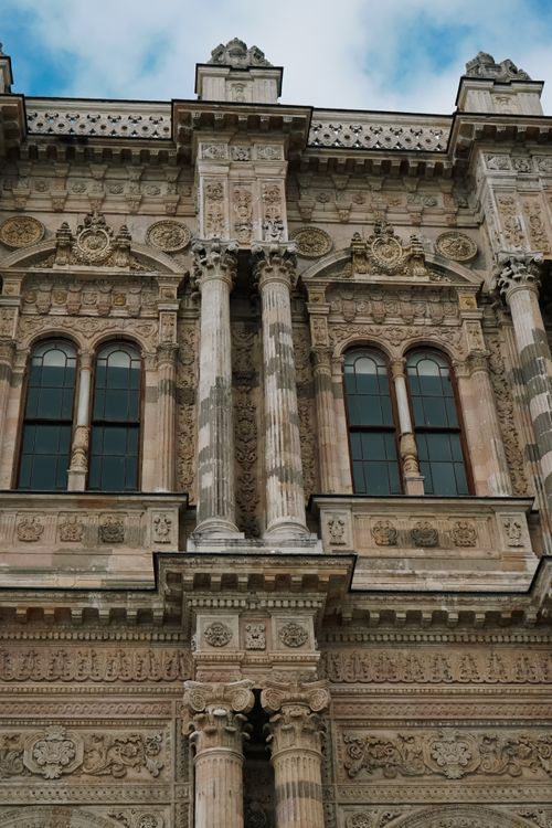 Free Detailed view of a historic facade with ornate columns and arched windows, capturing architectural beauty. Stock Photo
