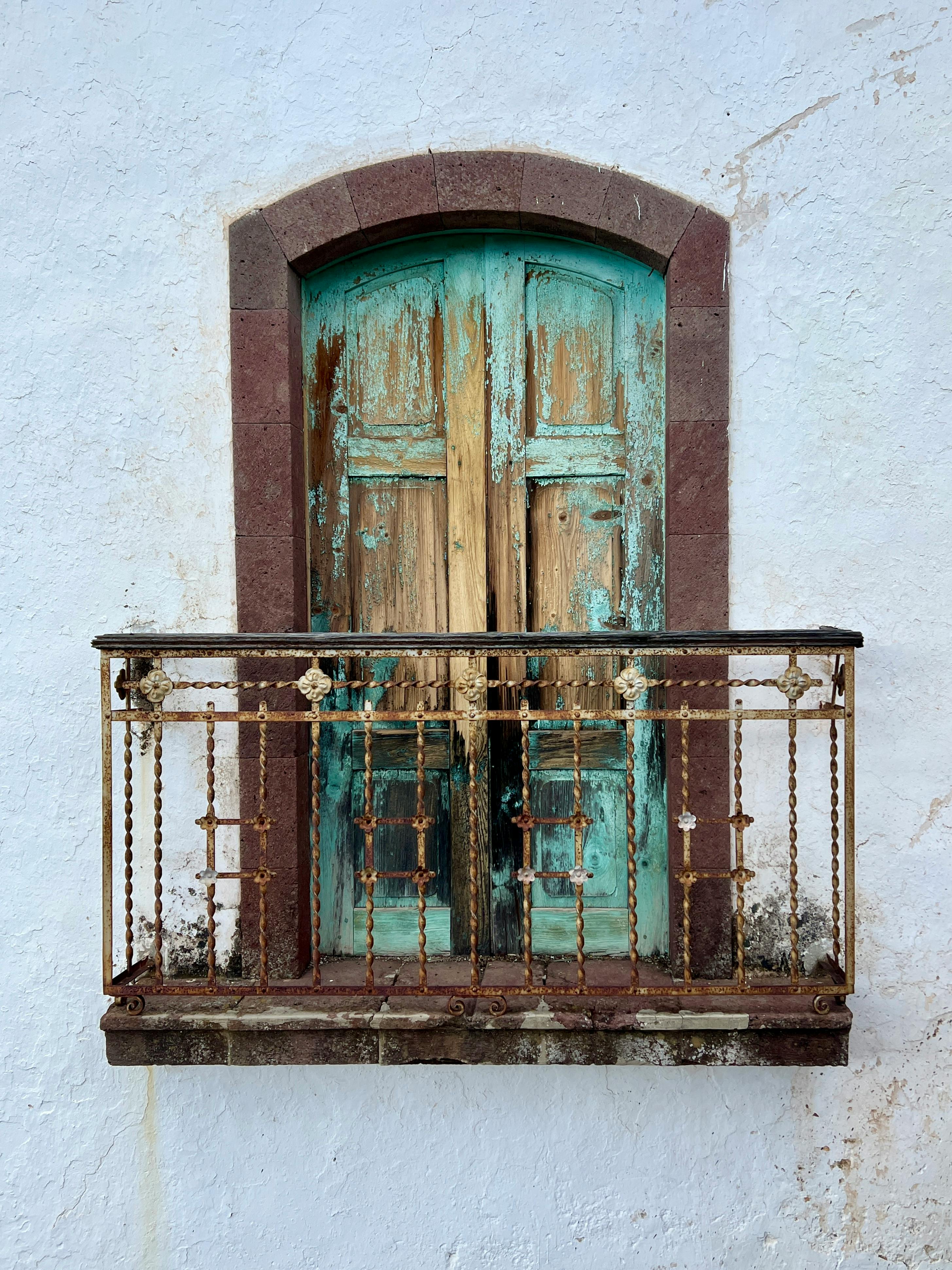 ingyenes Egy rusztikus, viharvert erkély egy vintage ajtóval betekintést nyújt a történelmi építészetbe. Stockfotó