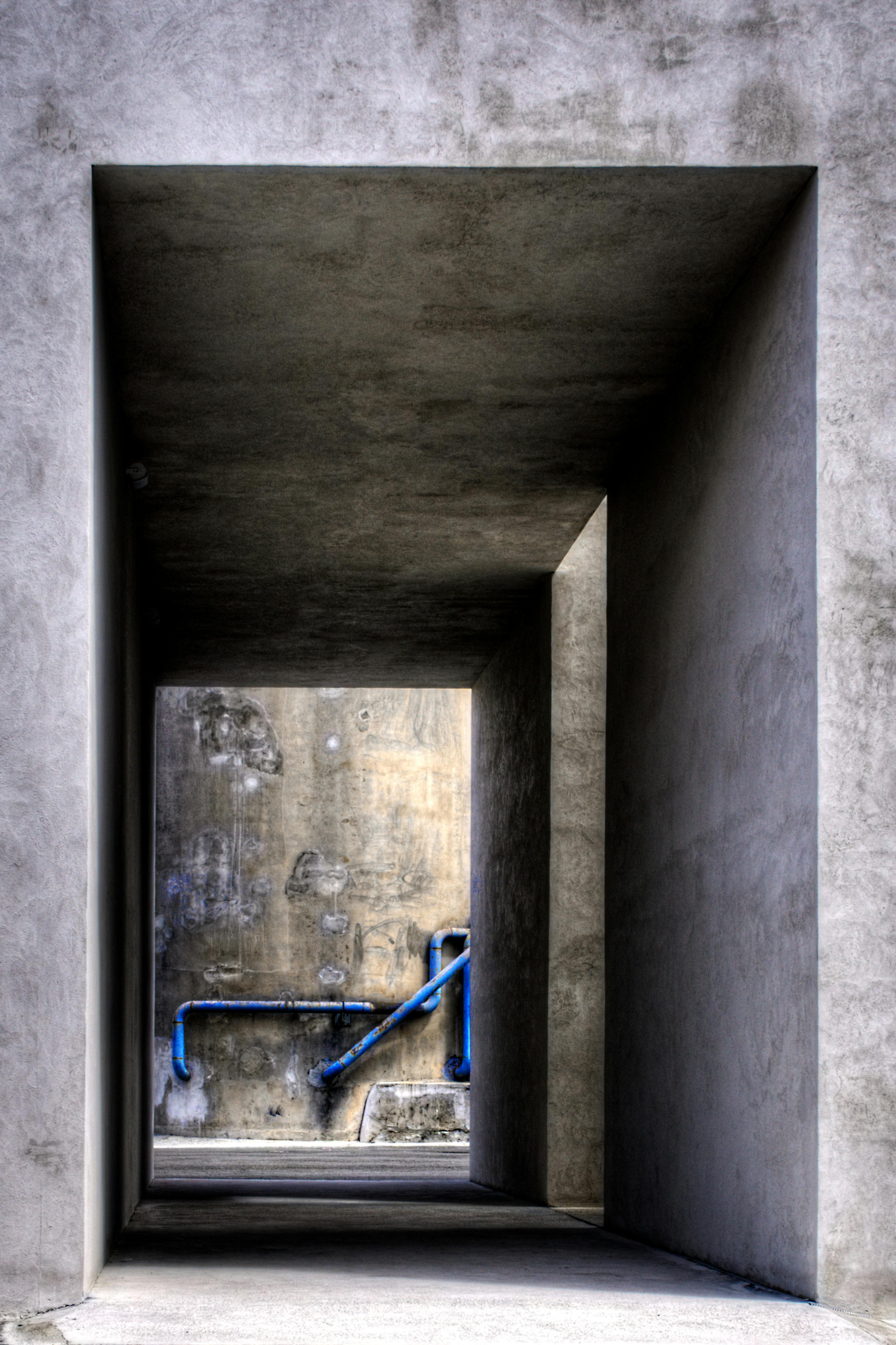 ฟรี ทางเดินคอนกรีตที่มีท่อสีน้ำเงินโดดเด่น สร้างฉากสถาปัตยกรรมสมัยใหม่ในเมืองอา โกรูญา ประเทศสเปน คลังภาพถ่าย