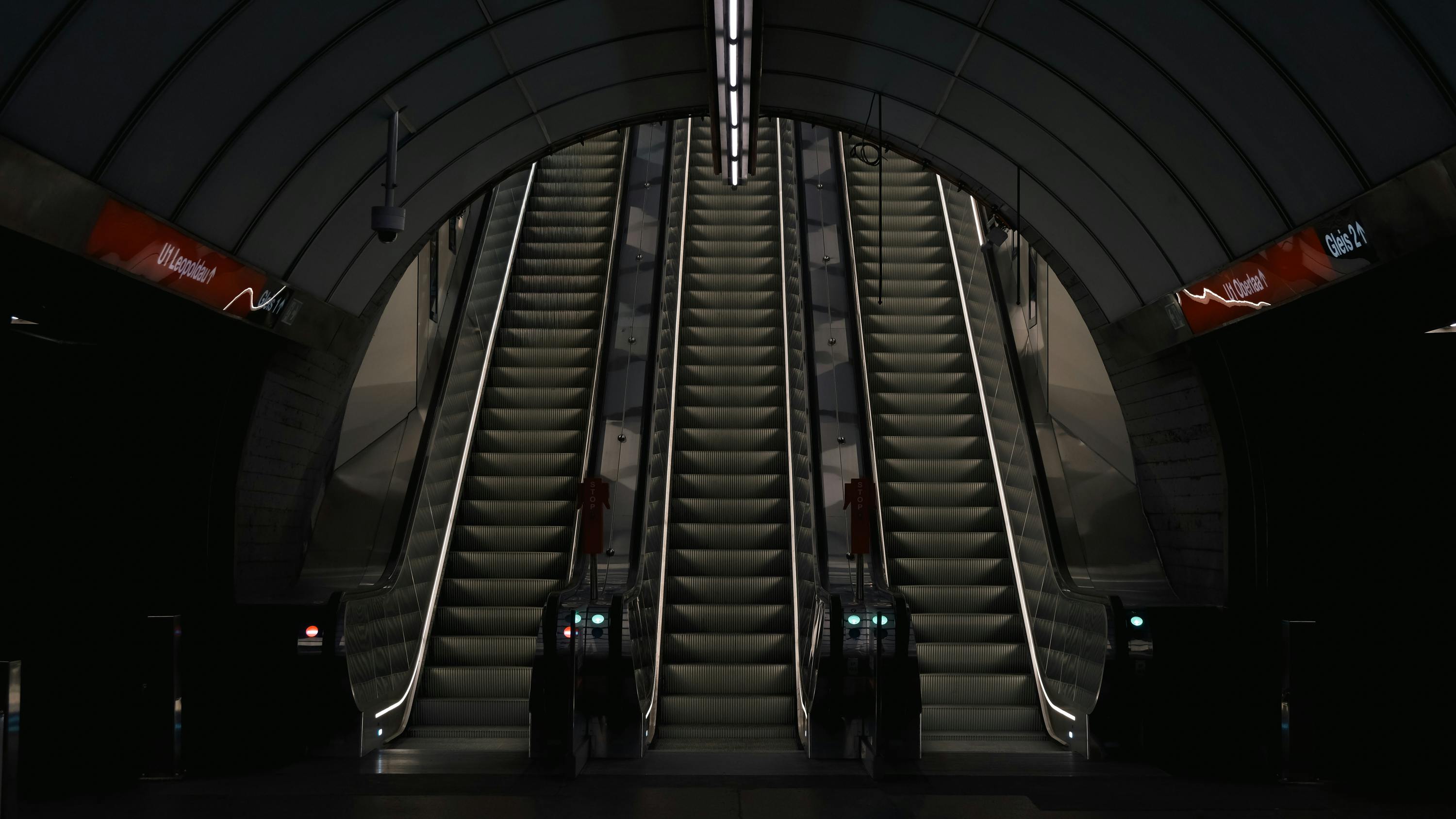 ingyenes A bécsi metróállomás mozgólépcsőinek szimmetrikus képe, amely a modern építészetet mutatja be. Stockfotó