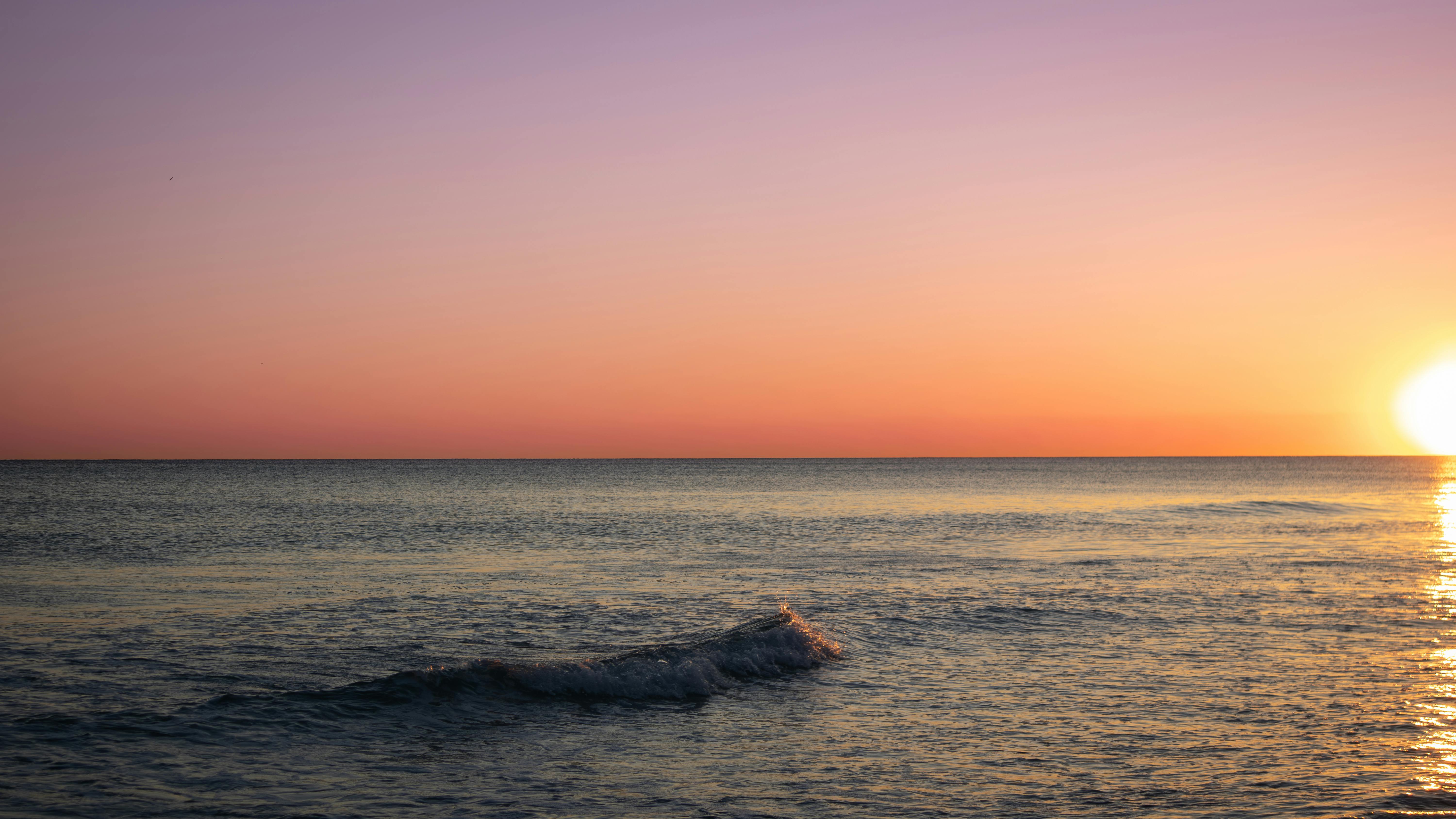 免費 佛羅裡達州聖羅莎海灘的日落景色令人陶醉，天空絢麗多彩，海面平靜無波。 圖庫相片