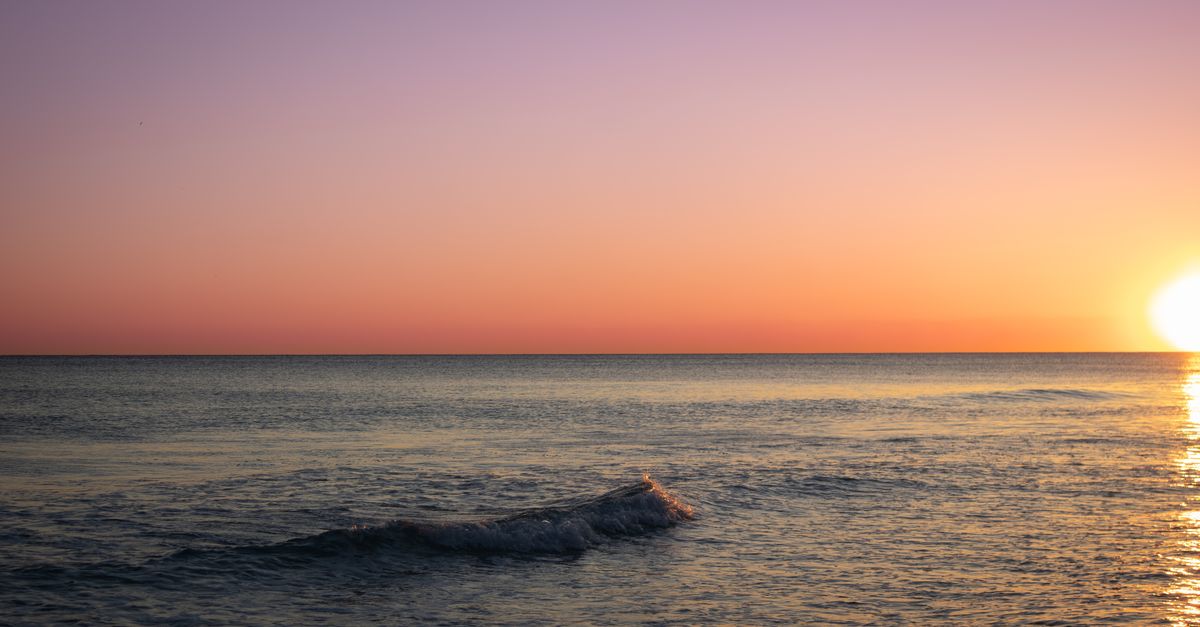 Captivating sunset view at Santa Rosa Beach, Florida, with vibrant sky and calm ocean waves.