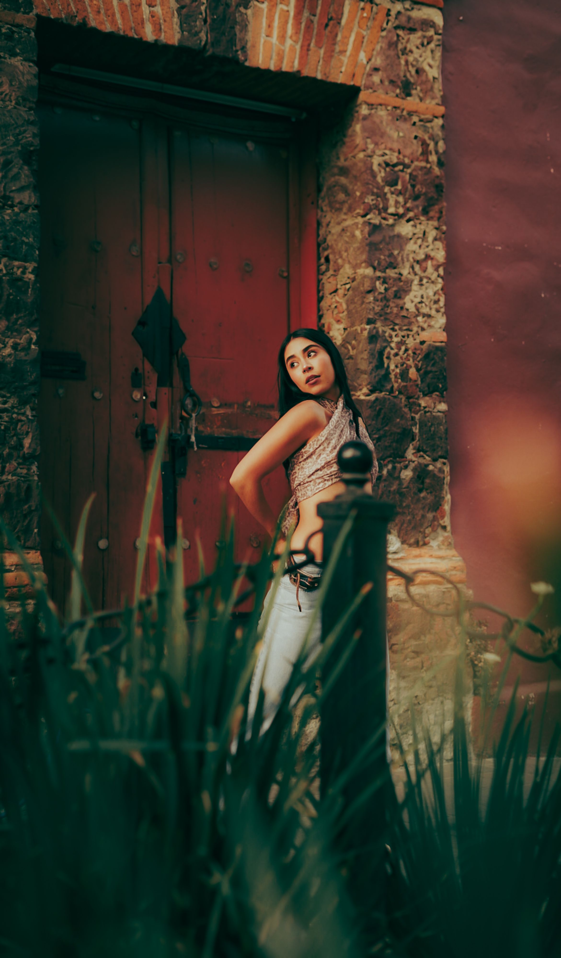 Woman Posing by Rustic Door in Urban Setting · Free Stock Photo