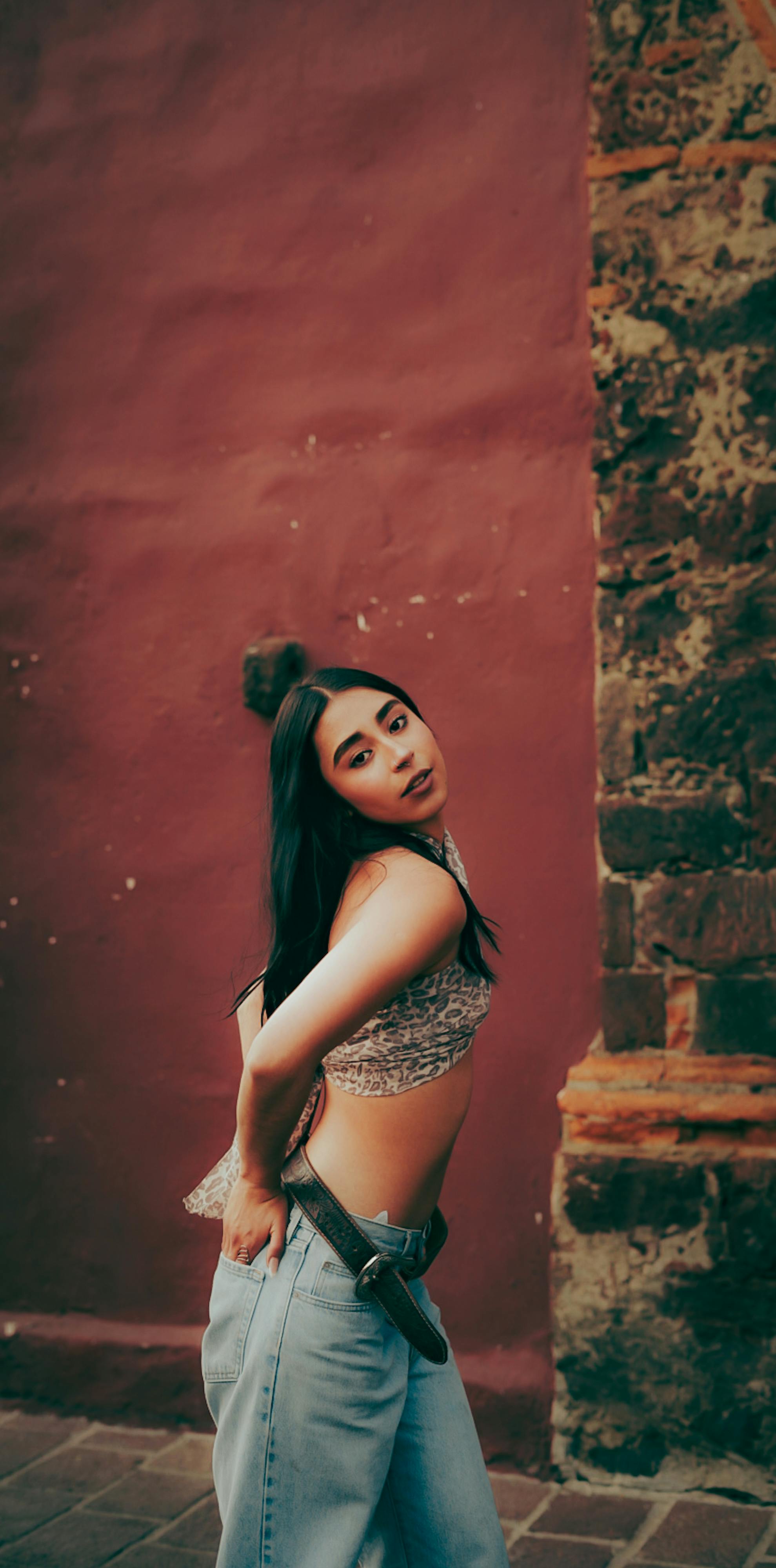 ฟรี หญิงสาวสวยมีสไตล์โพสท่าอย่างมั่นใจโดยมีฉากหลังเป็นกำแพงไม้แบบชนบท คลังภาพถ่าย