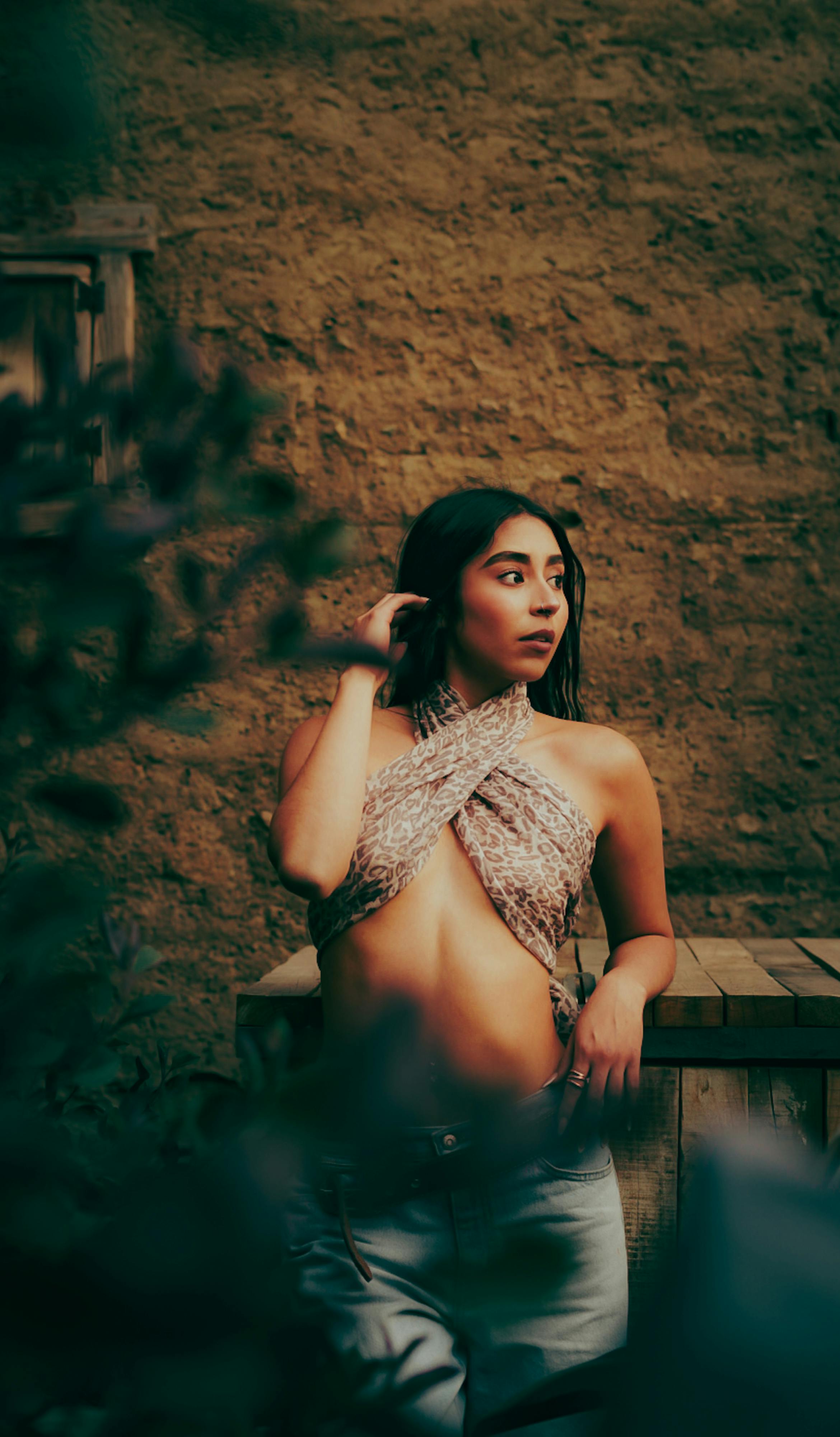 ฟรี ภาพถ่ายบุคคลสุดเก๋ของหญิงสาวในเสื้อตัวเก๋ ยืนอยู่กลางแจ้งโดยมีฉากหลังเป็นกำแพงไม้แบบชนบท คลังภาพถ่าย