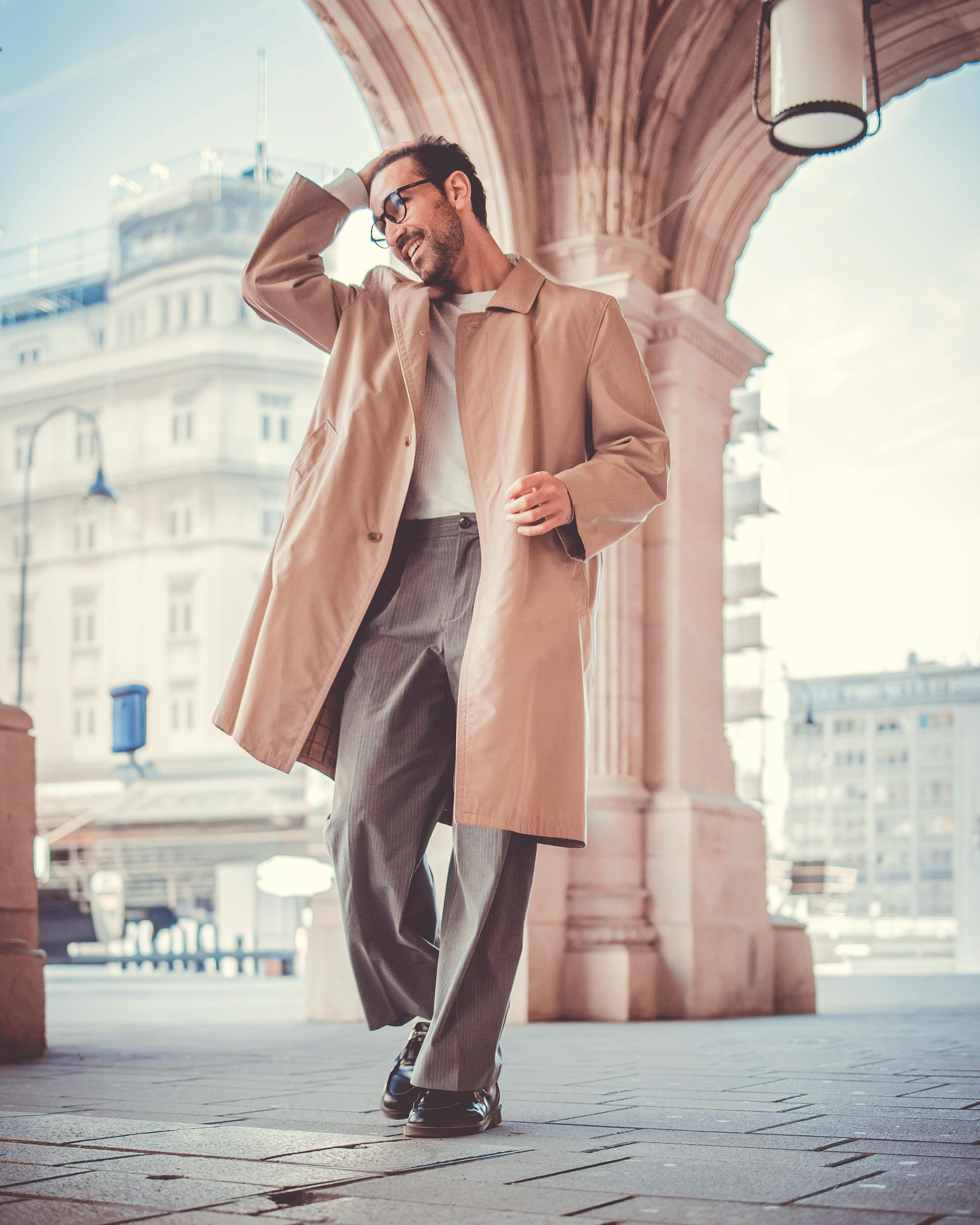 bezplatná Módní muž ve slunečních brýlích pózuje pod obloukem ve Vídni a zachycuje městskou eleganci. Základová fotografie