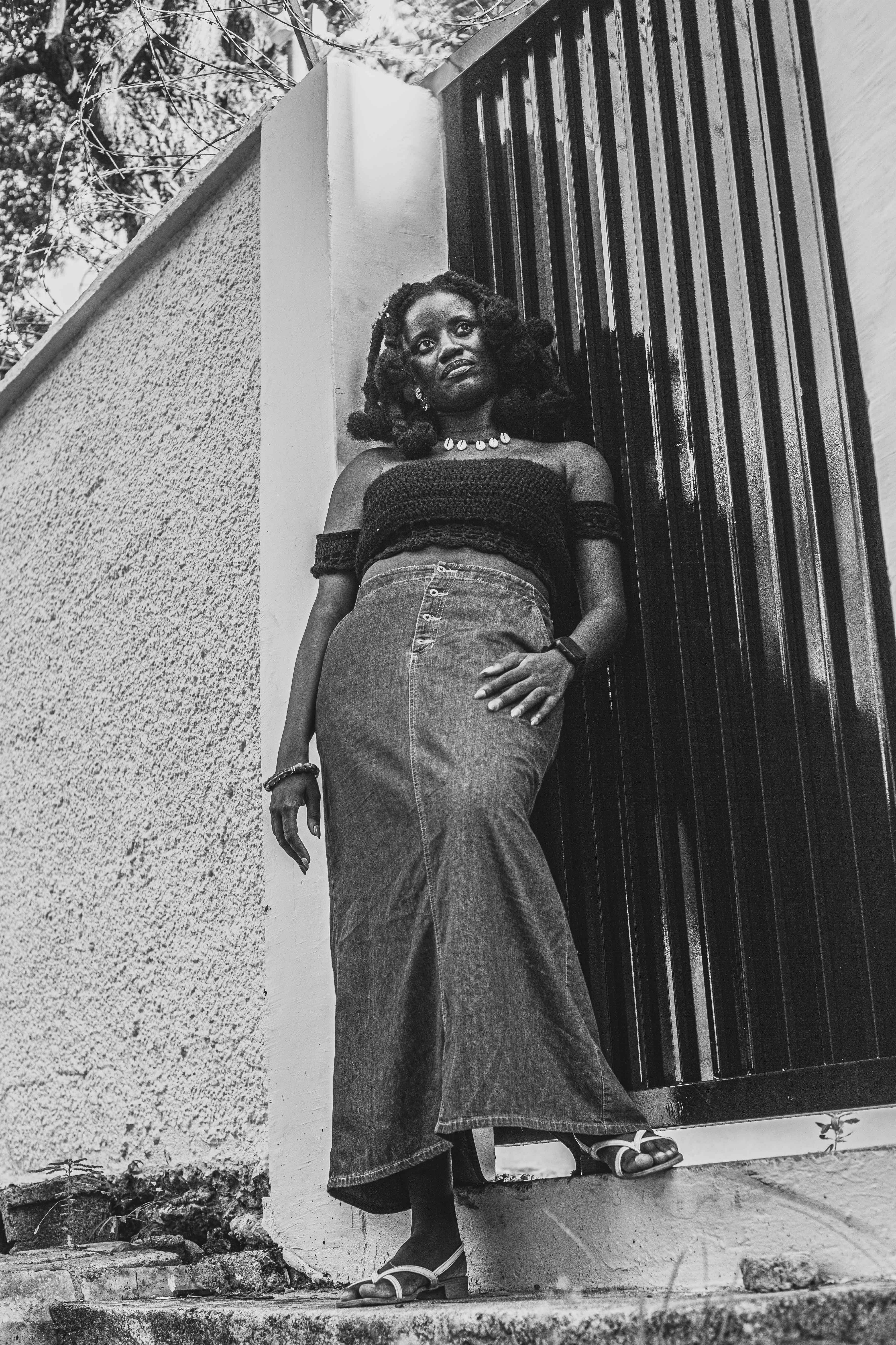 Miễn phí Bức chân dung đen trắng trang nhã của một người phụ nữ đang tựa vào cổng ngoài trời ở Accra. Ảnh lưu trữ
