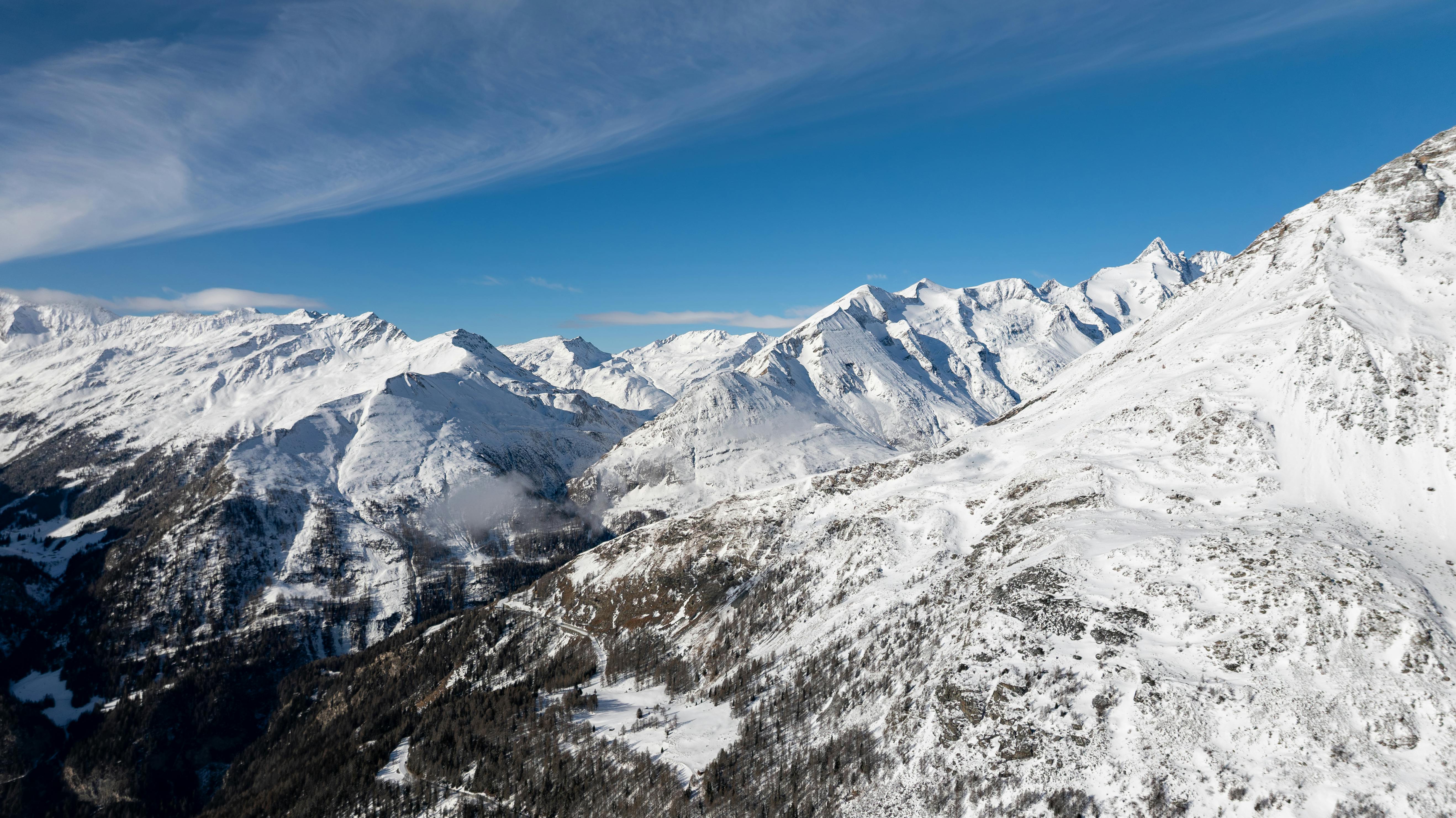 ฟรี ภาพภูเขาที่ปกคลุมด้วยหิมะสวยงามในโครูทานี ประเทศออสเตรีย เผยให้เห็นยอดเขาแอลป์ภายใต้ท้องฟ้าสีครามสดใส คลังภาพถ่าย
