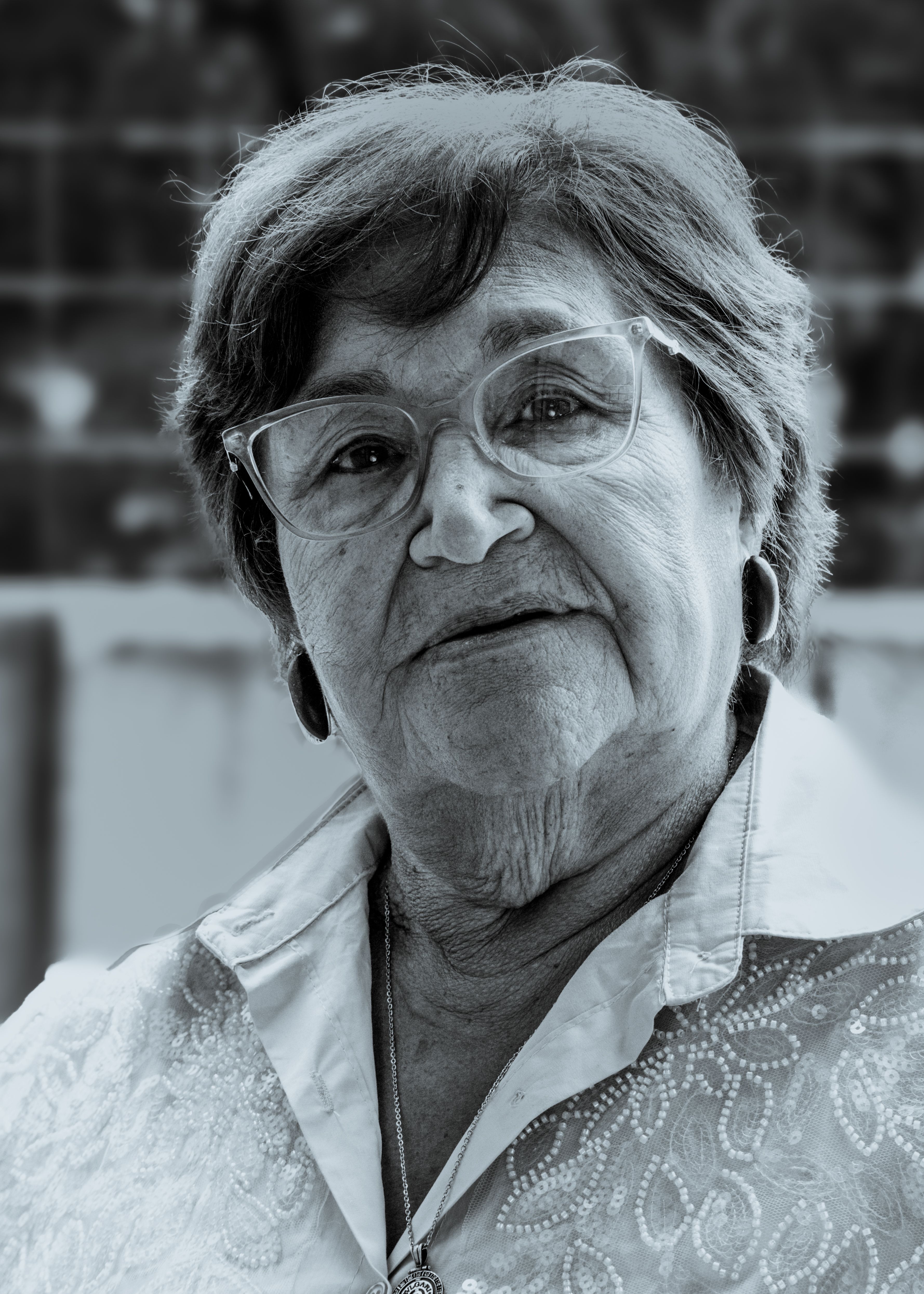 Close-up black and white portrait of an elder woman wearing glasses outdoors in Buenos Aires.