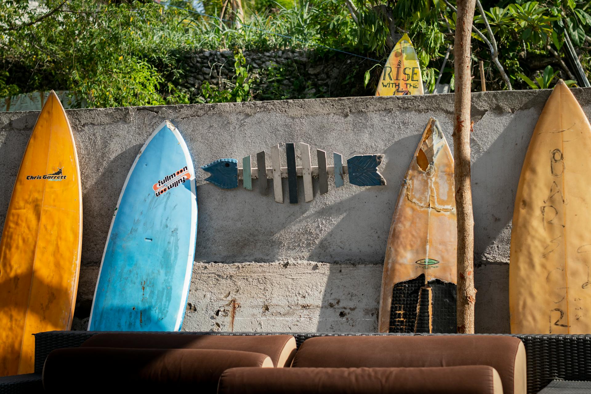 Vibrant surfboards leaning against a wall, showcasing an outdoor seaside vibe.