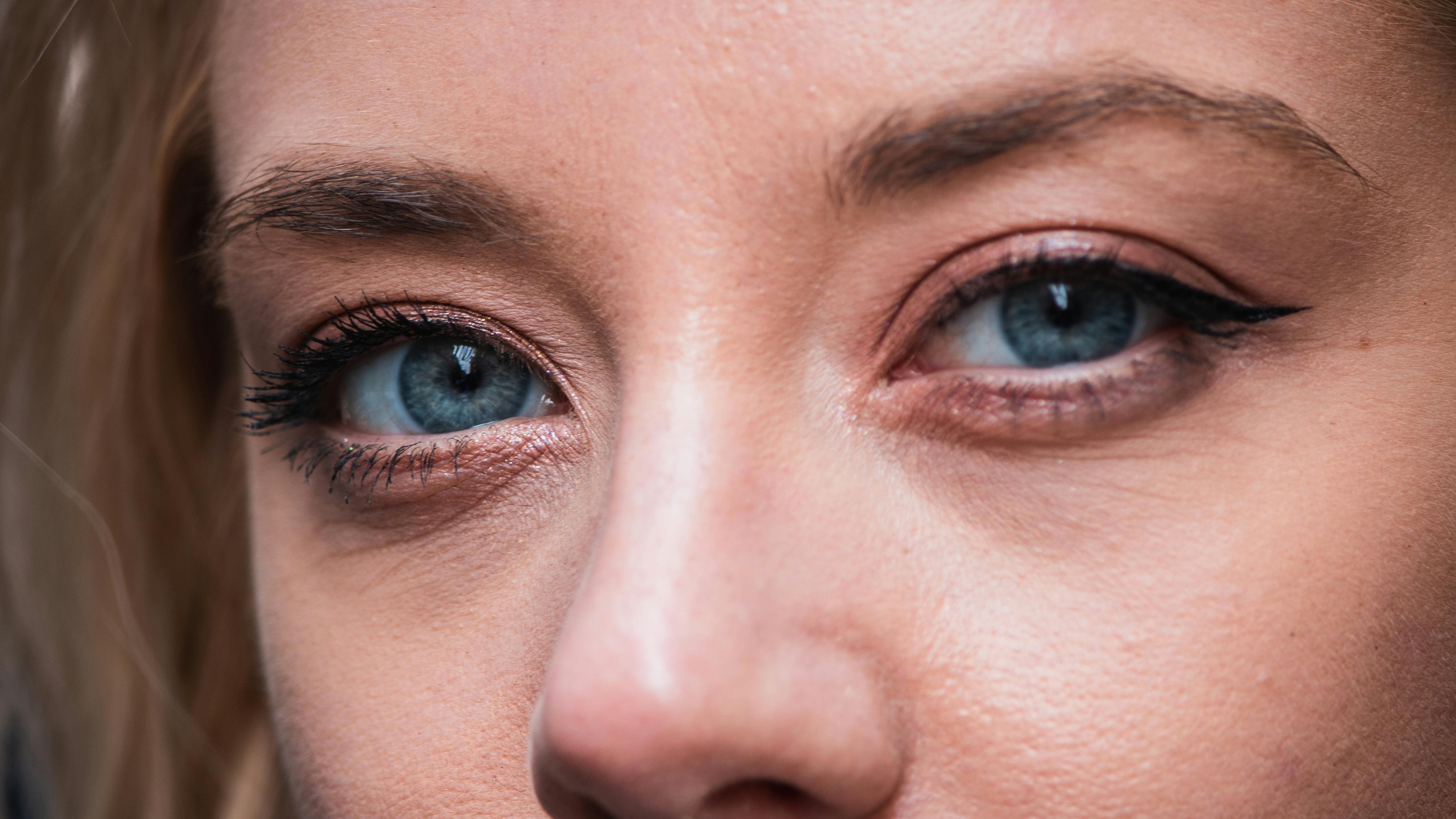 bezplatná Detailní záběr modrých očí ženy, zvýrazňující přirozený make-up a oční linky. Základová fotografie