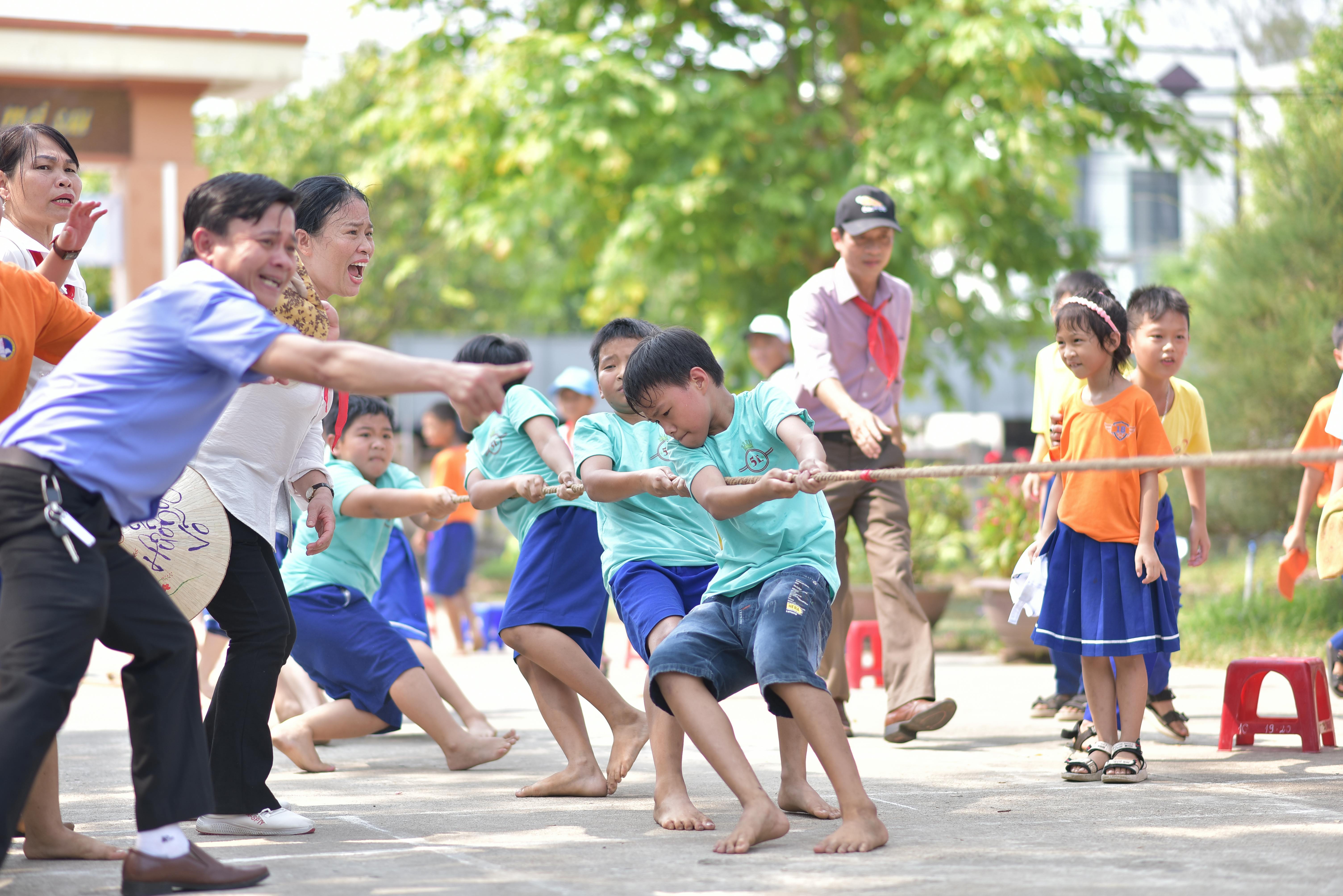 Безкоштовне Жвава гра в перетягування каната для дітей та дорослих на свіжому повітрі під сонцем. Ідеально підходить для зображення командної роботи та веселощів. стокове фото