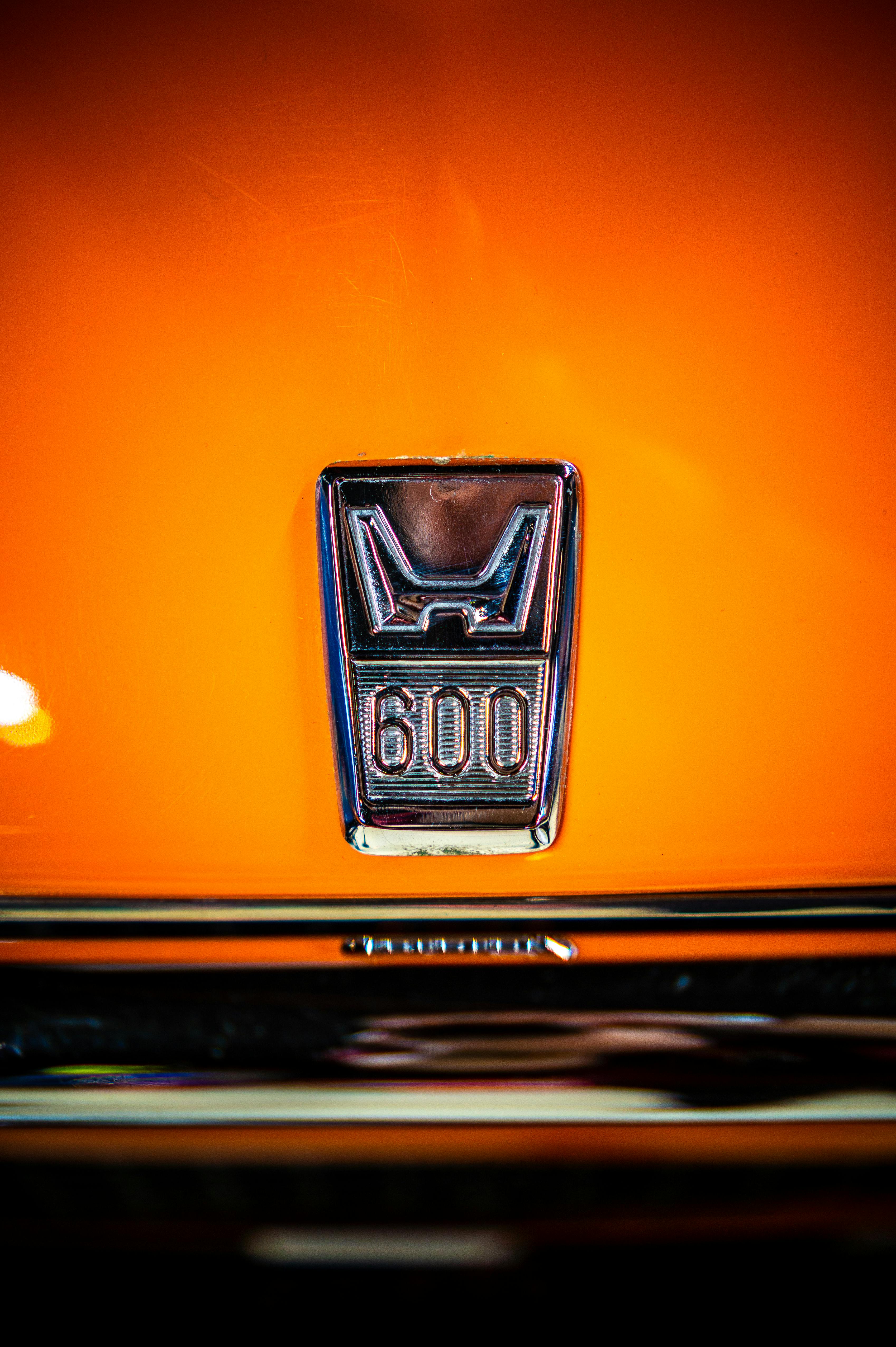 Zadarmo Detailný záber emblému veterána na výraznom oranžovom pozadí, ktorý zvýrazňuje retro automobilový štýl. Fotka z fotobanky