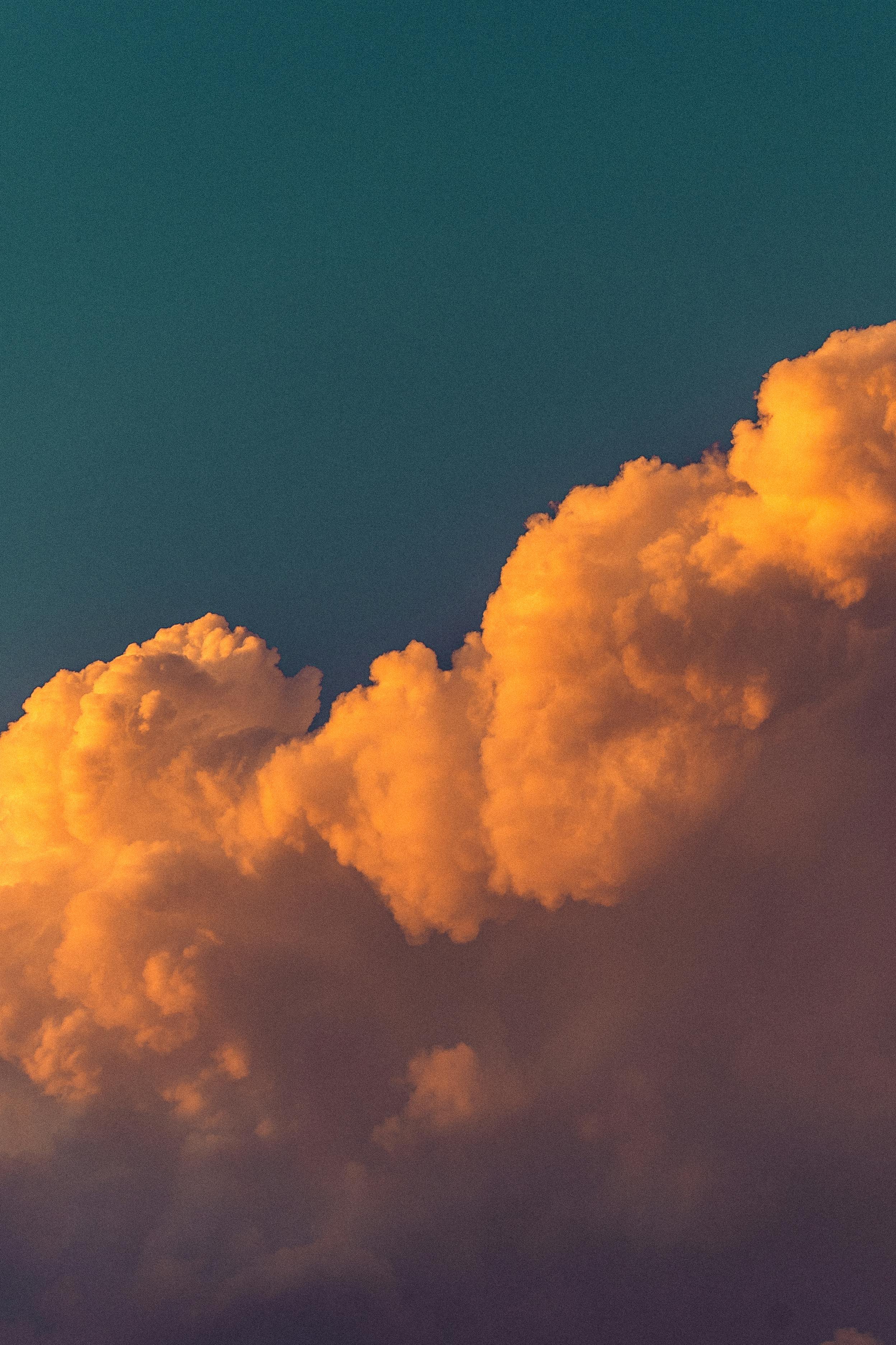 Zadarmo Žiarivo oranžové oblaky pri západe slnka zapadajúce na pozadí tmavomodrej oblohy zachytávajú pokojný okamih. Fotka z fotobanky