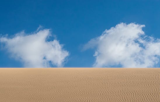 在哥伦比亚的拉瓜希拉，广阔的波纹沙丘与清澈的蓝天相接，云朵蓬松