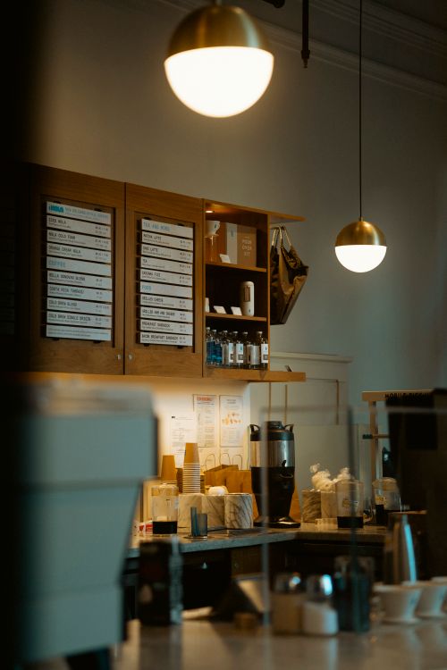 Free Warm interior of a New York City cafe with ambient lighting and coffee station. Stock Photo