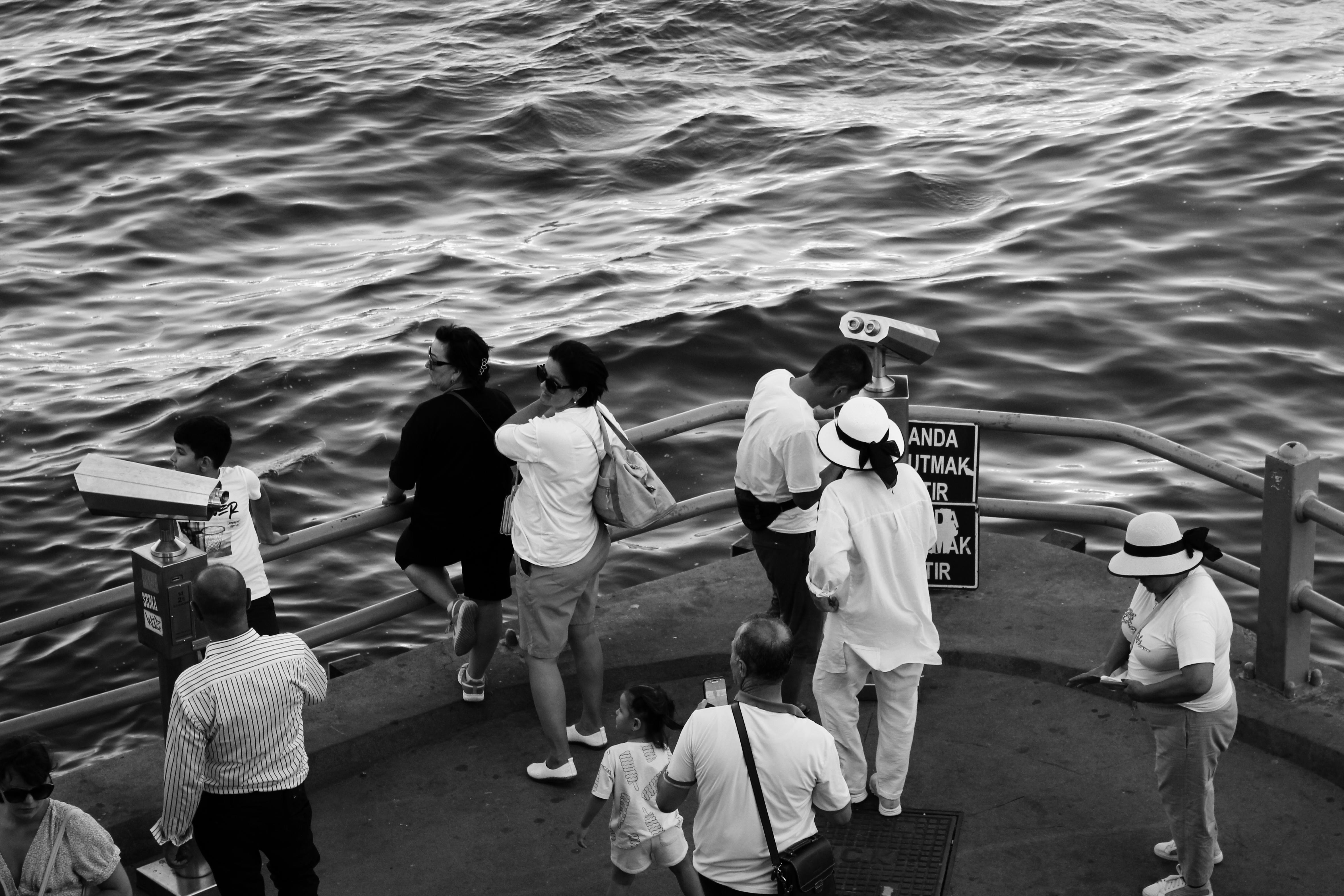 ฟรี ผู้คนหลากหลายกลุ่มกำลังเพลิดเพลินกับทิวทัศน์ริมน้ำของอิสตันบูลที่ชายหาดอูสคูดาร์ คลังภาพถ่าย