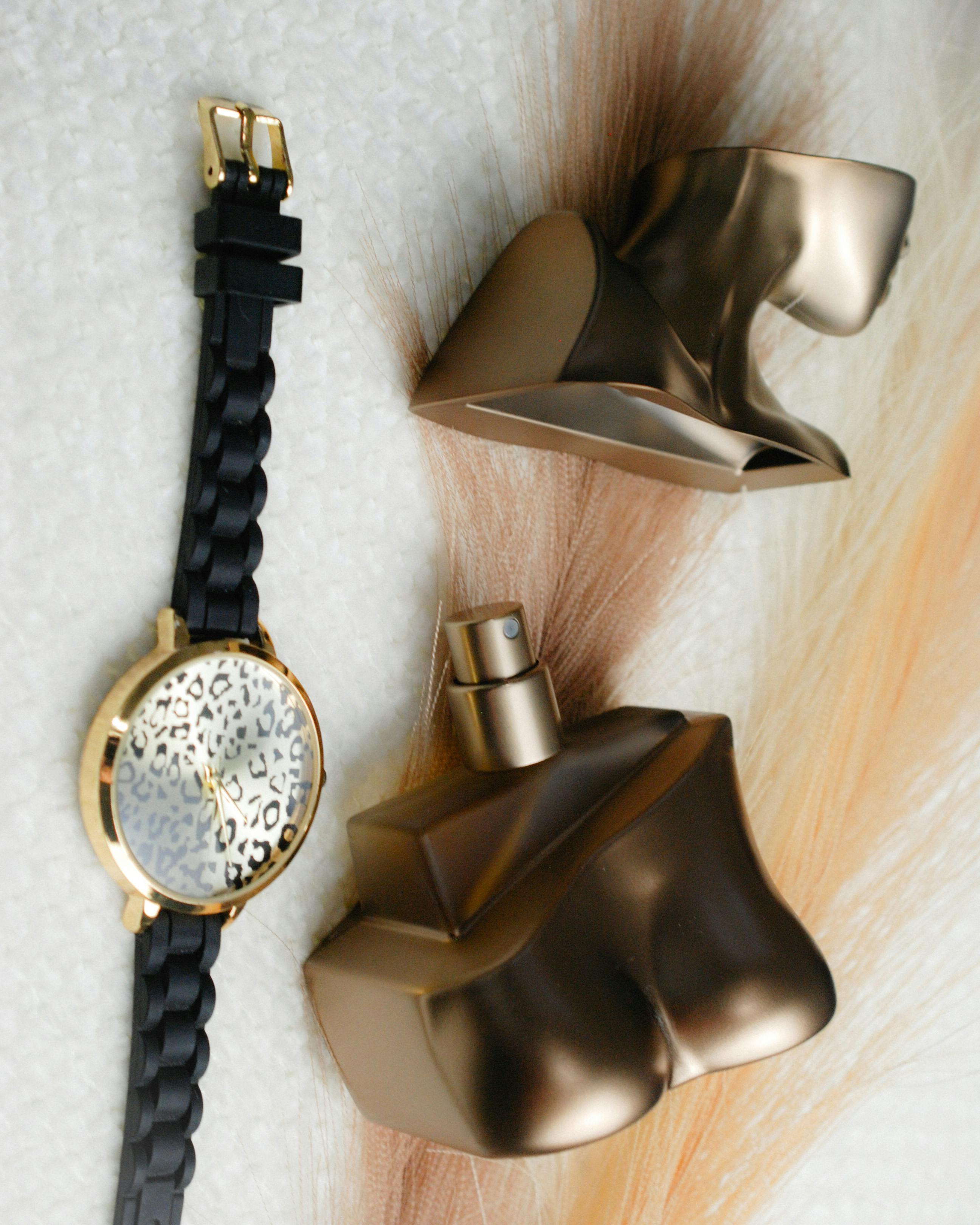 ฟรี ขวดน้ำหอมสีทองหรูหรา จับคู่กับนาฬิกาข้อมือสีดำทองสุดเก๋ คลังภาพถ่าย