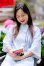 Woman Reading Book Surrounded by Flowers Outdoors