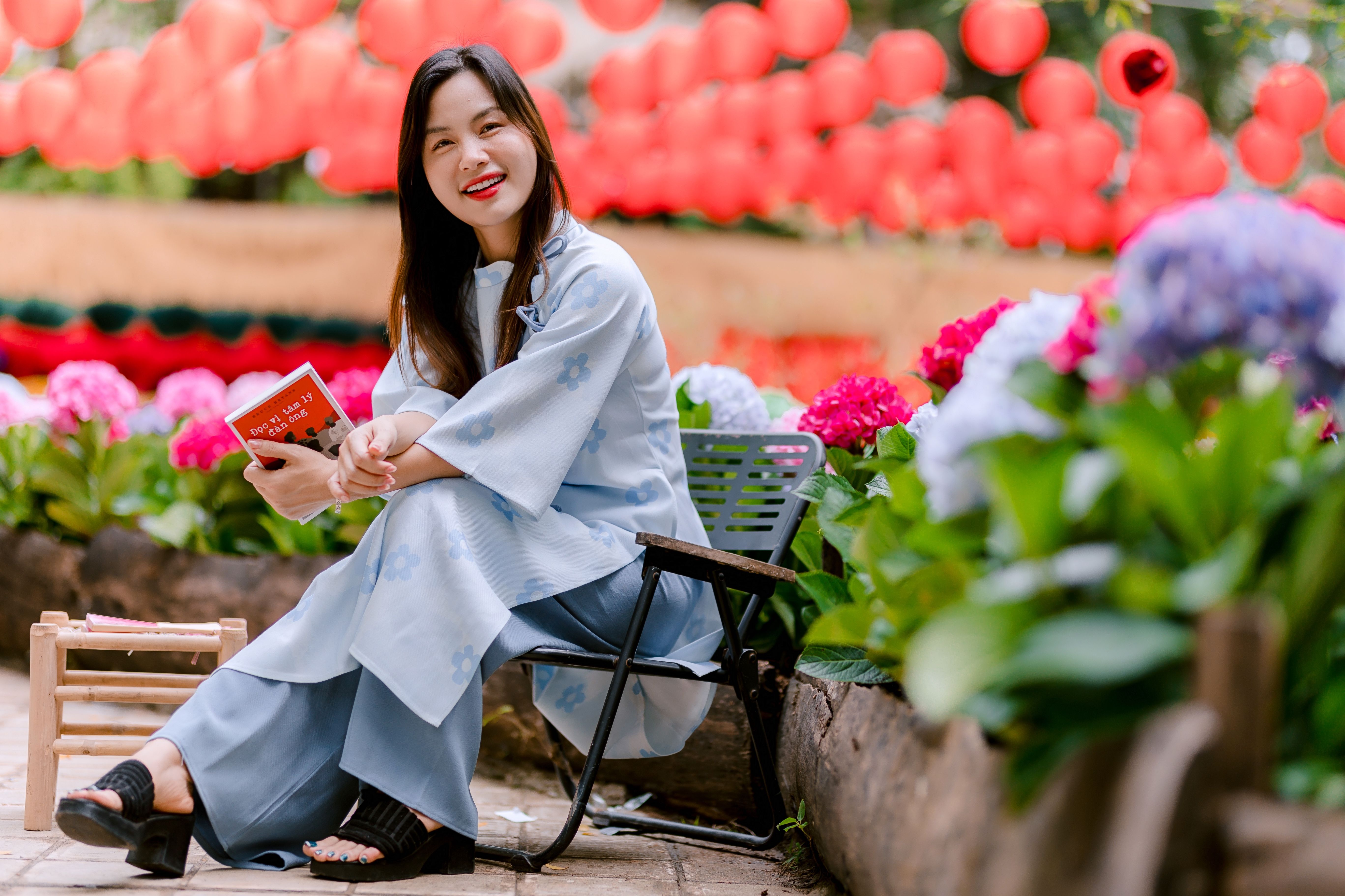 Woman Reading in Garden with Red Lanterns