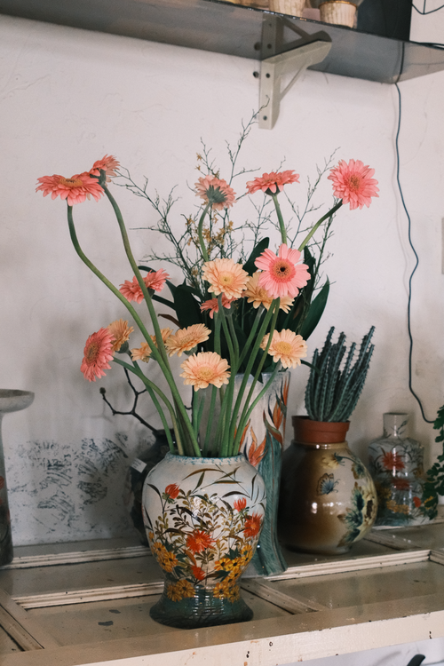 Free Pink gerbera daisies in a decorative ceramic vase on a shelf in Ho Chi Minh City. Stock Photo