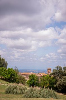 Serene view of Italy's rolling hills and historic architecture under a vibrant sky.