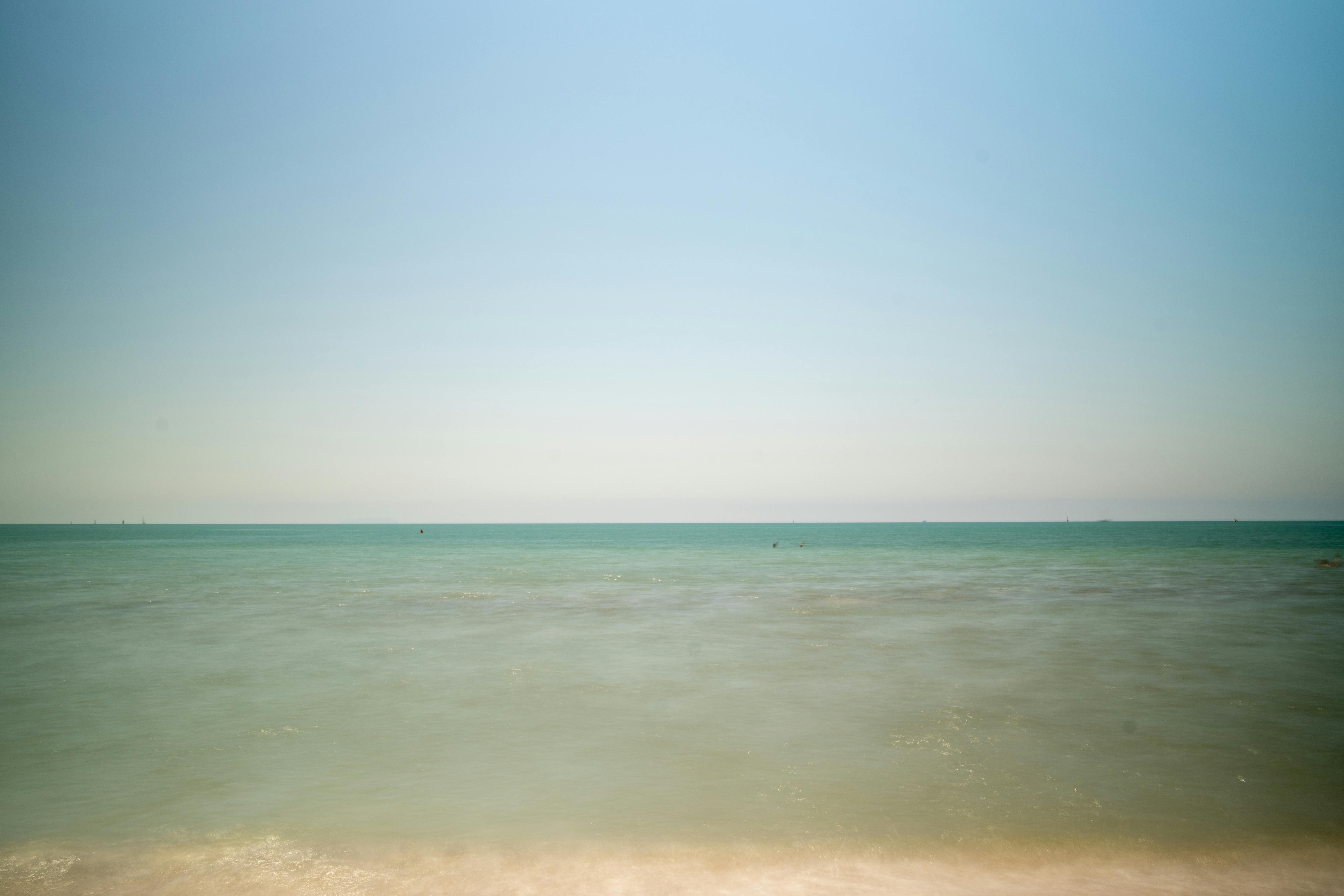 ฟรี ภาพชายหาดอันเงียบสงบในอิตาลี ท้องฟ้าสีฟ้าสดใสและน้ำทะเลสีเทอร์quoise เหมาะอย่างยิ่งสำหรับการพักผ่อนหรือสร้างแรงบันดาลใจในการท่องเที่ยว คลังภาพถ่าย