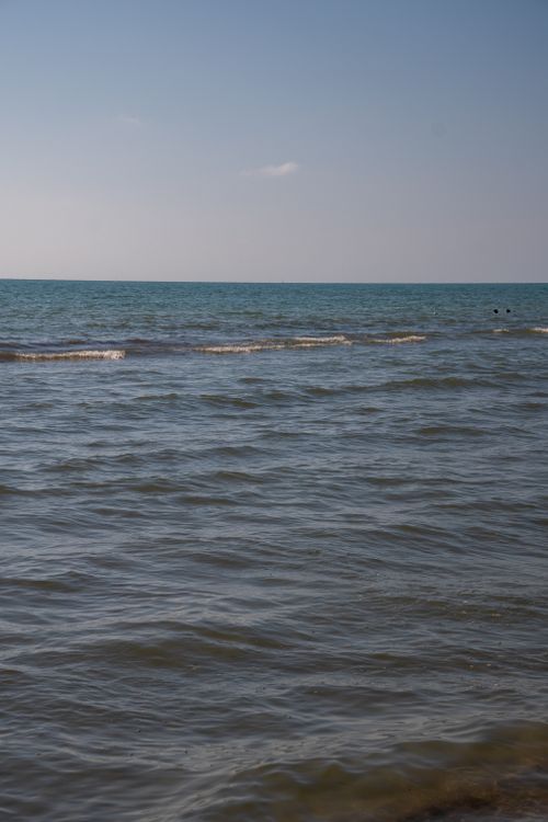 Free Serene view of the Italian coast with gentle waves and clear blue skies, perfect for summer relaxation. Stock Photo