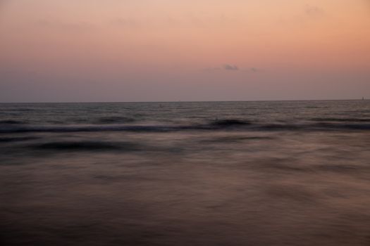 A serene sunset over the calm waters of the Italian coastline, capturing a peaceful ambiance.