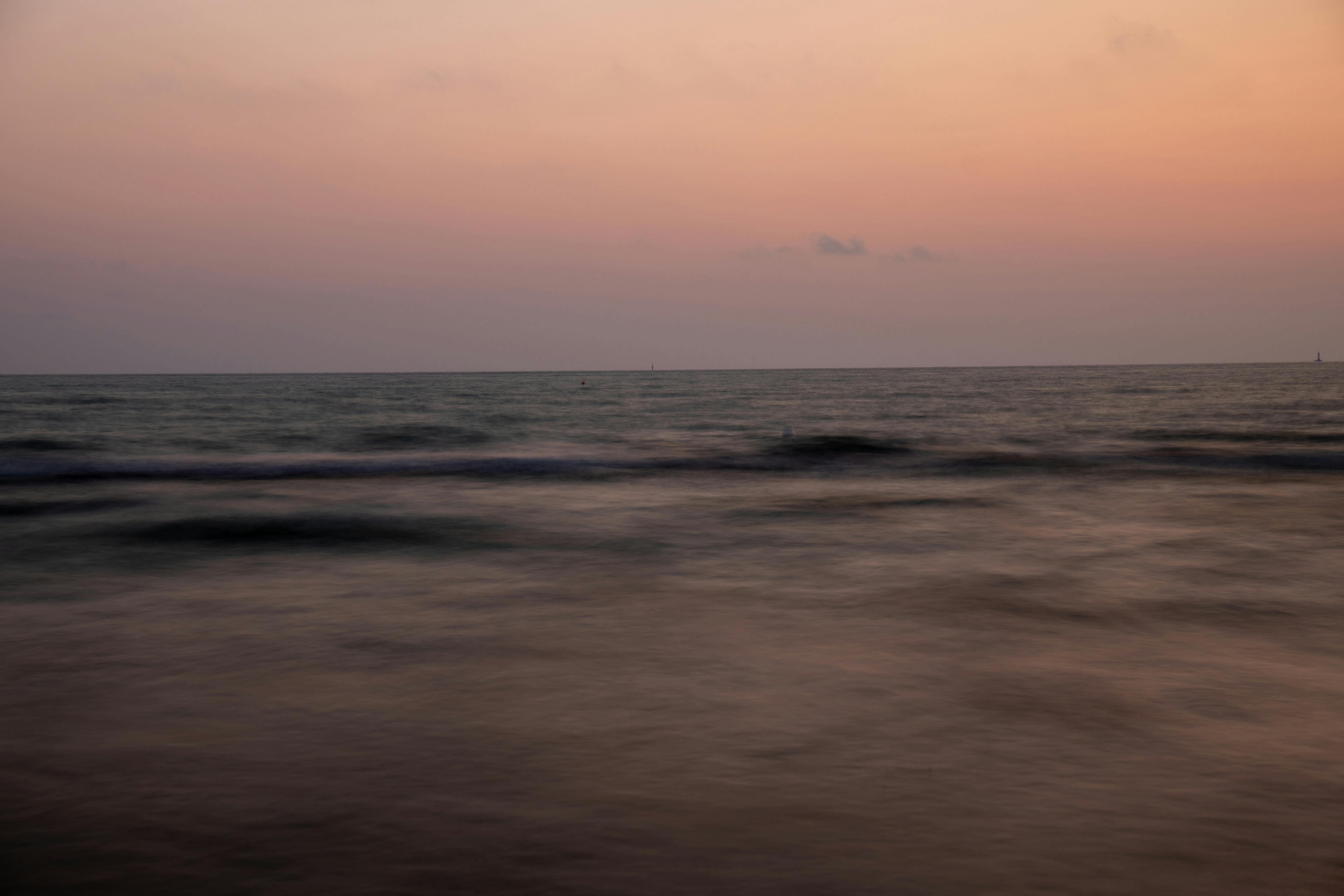 Miễn phí Một cảnh hoàng hôn thanh bình trên mặt nước tĩnh lặng của bờ biển Ý, ghi lại một bầu không khí yên tĩnh. Ảnh lưu trữ