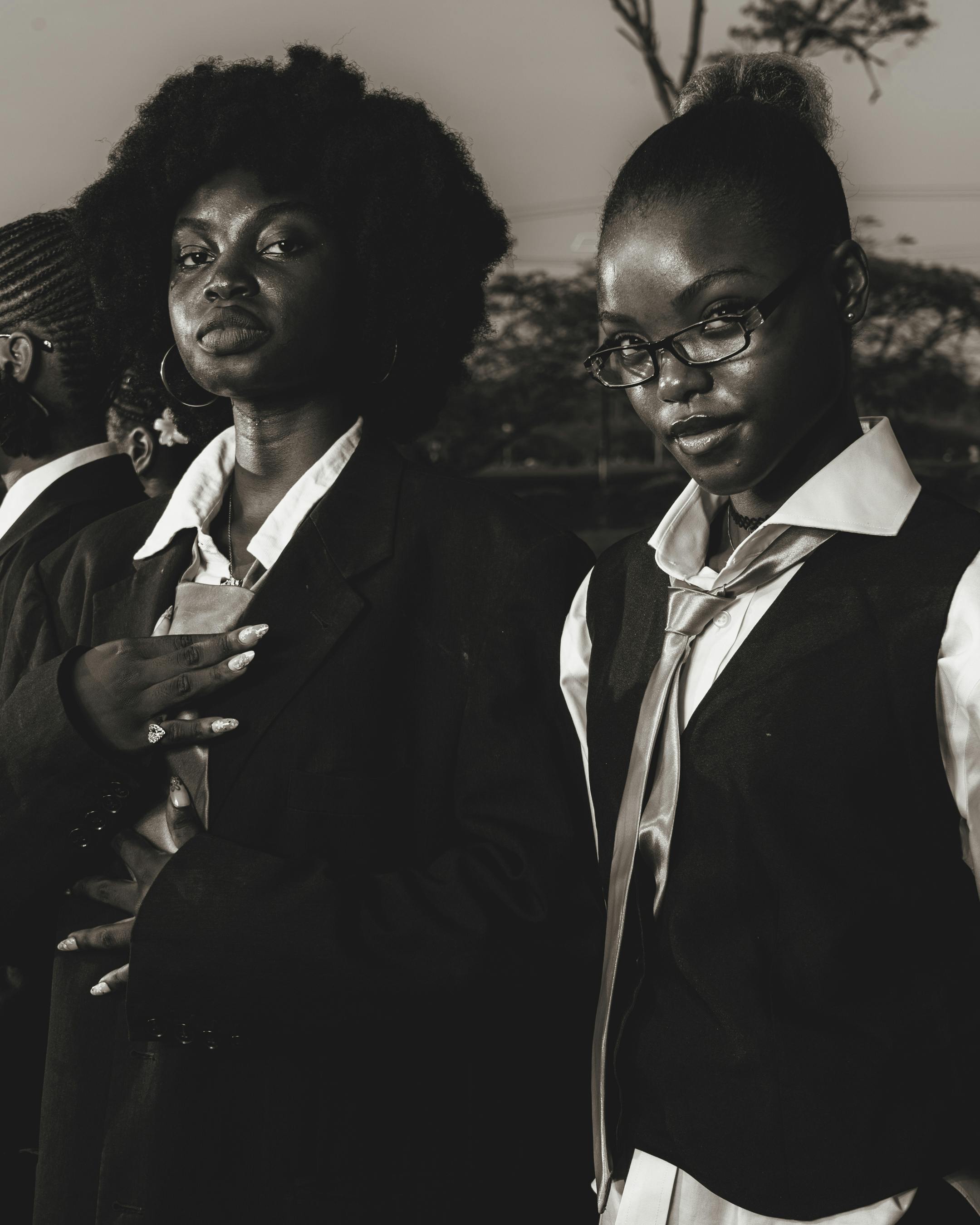 ingyenes Két magabiztos nő üzleti öltözékben, komoly modorral pózolnak a szabadban. Stockfotó