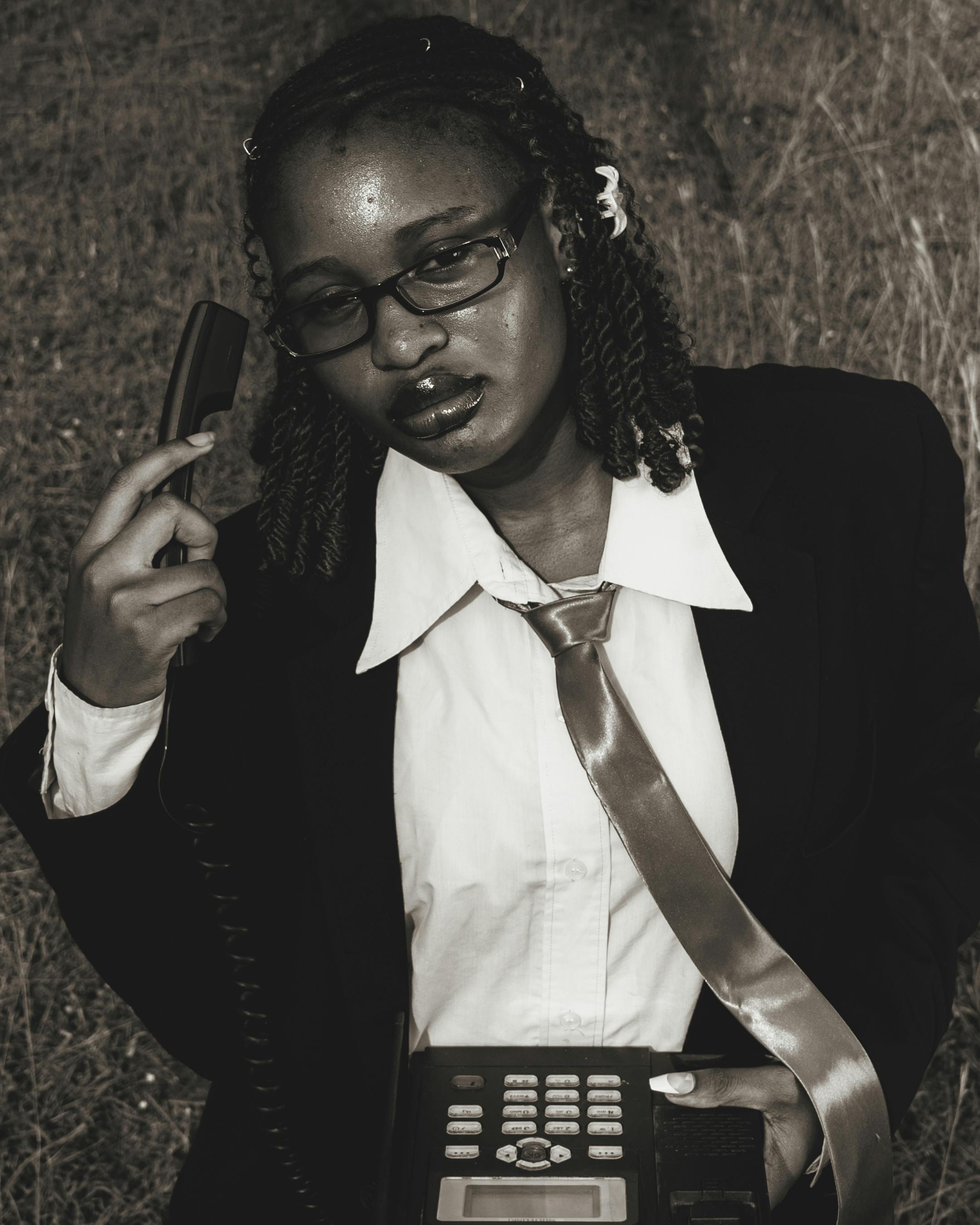 Безкоштовне Жінка у офіційному вбранні з вінтажним телефоном, яка позує на вулиці, додає класичного штриха бізнес-концепціям. стокове фото