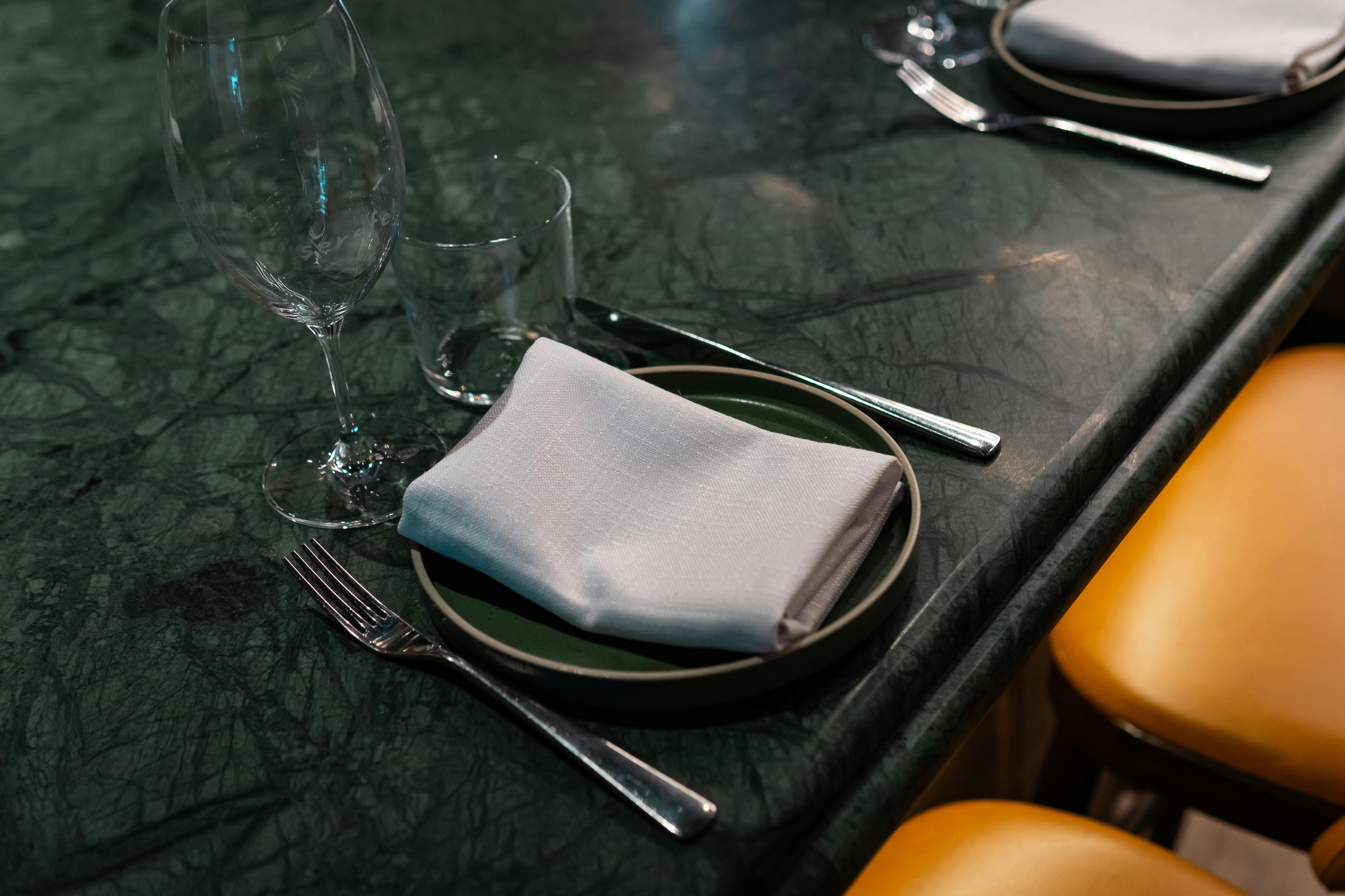 Безкоштовне Вишуканий обідній стіл зі скляним та срібним посудом на мармуровій поверхні. стокове фото