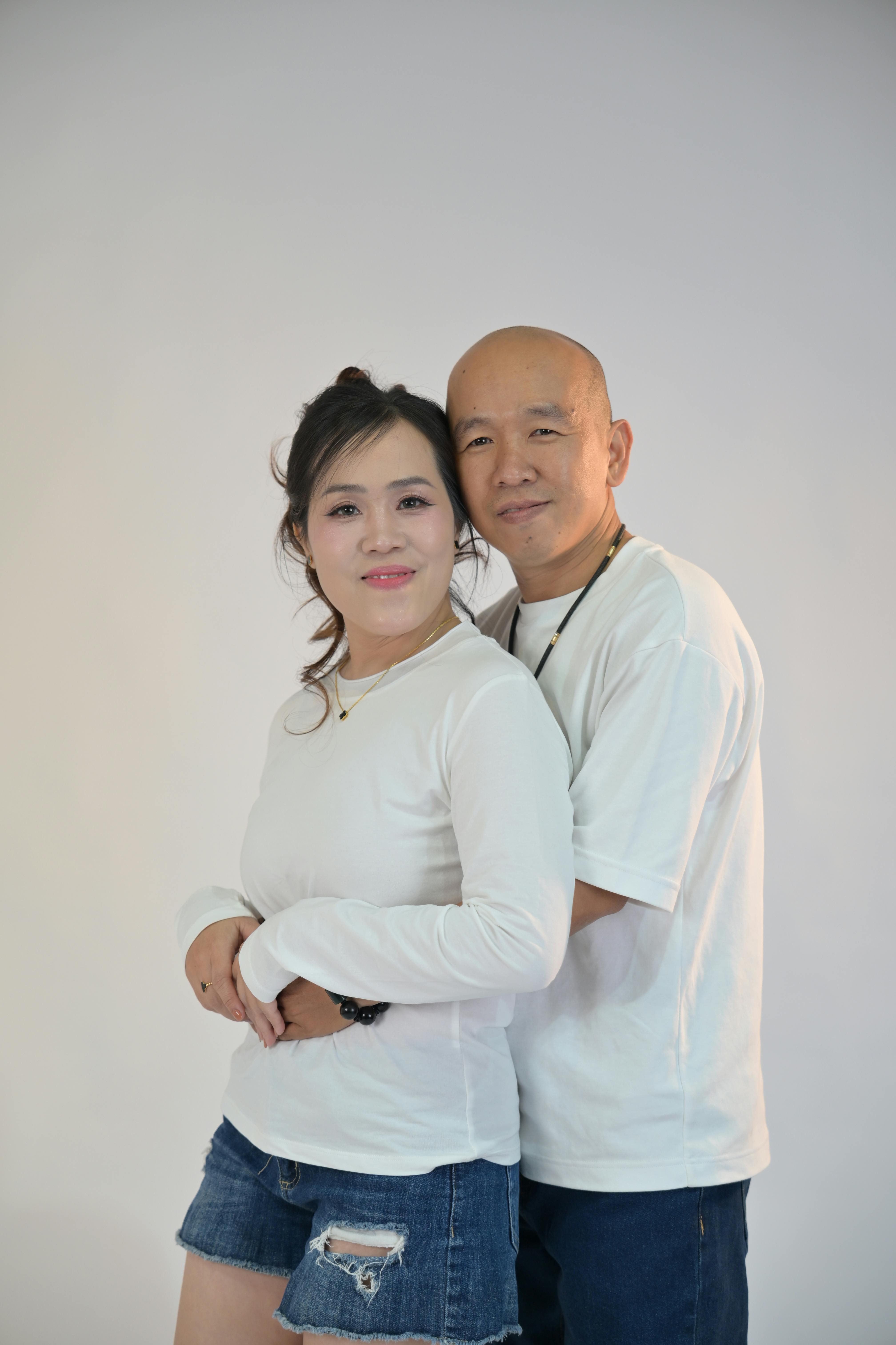 Zadarmo Radostný pár v ležérnom oblečení sa vrúcne objíma na neutrálnom pozadí. Fotka z fotobanky