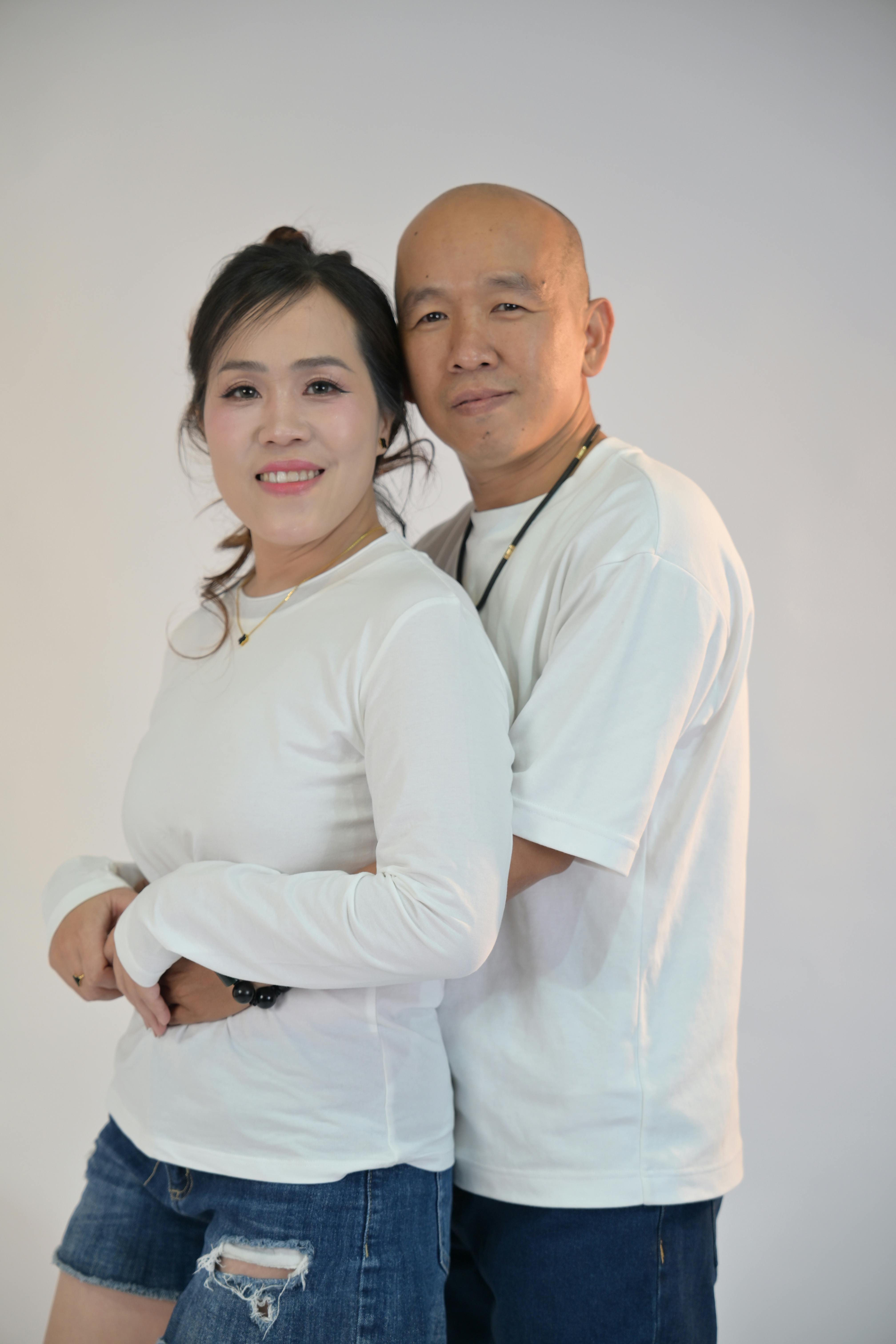 免费 一对身穿白衬衫的幸福情侣在摄影棚内亲密地合影。 素材图片