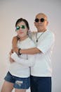 Casual Couple in Sunglasses Against Plain Background