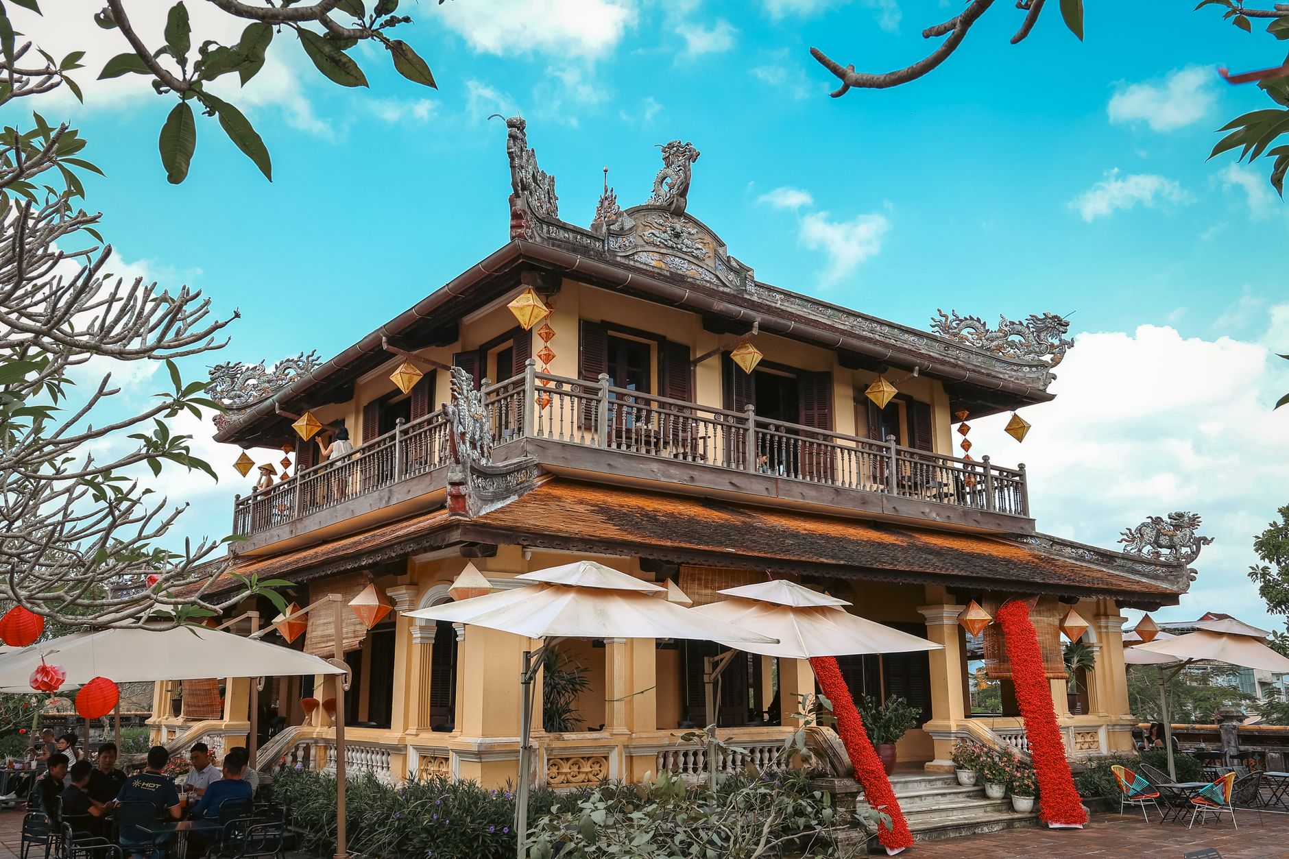 Elegant Vietnamese building in Hue showcasing traditional style and vibrant decorations in a garden setting.
