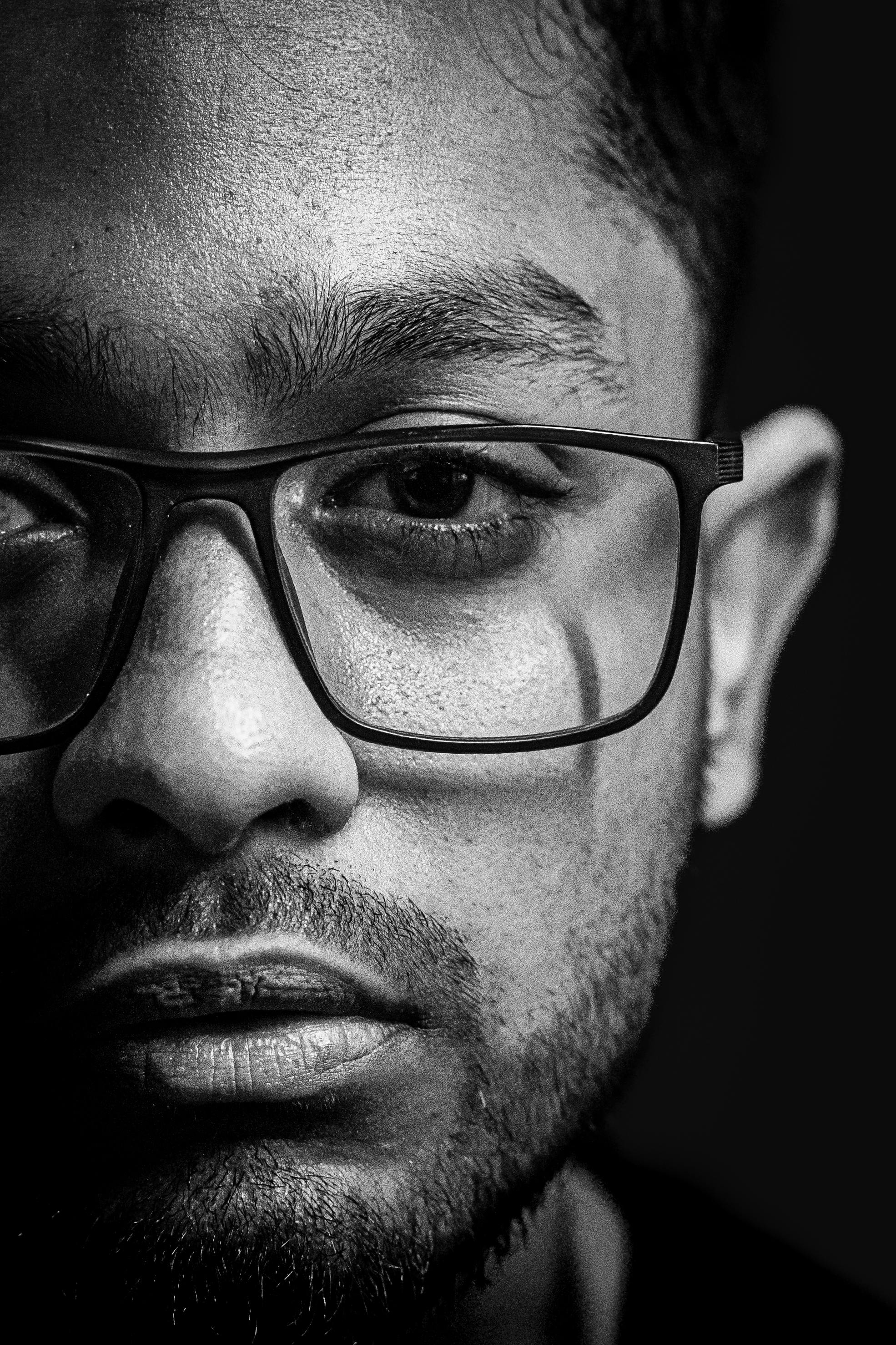 bezplatná Detailní černobílý portrét muže s brýlemi, vyjadřující rozjímání. Základová fotografie