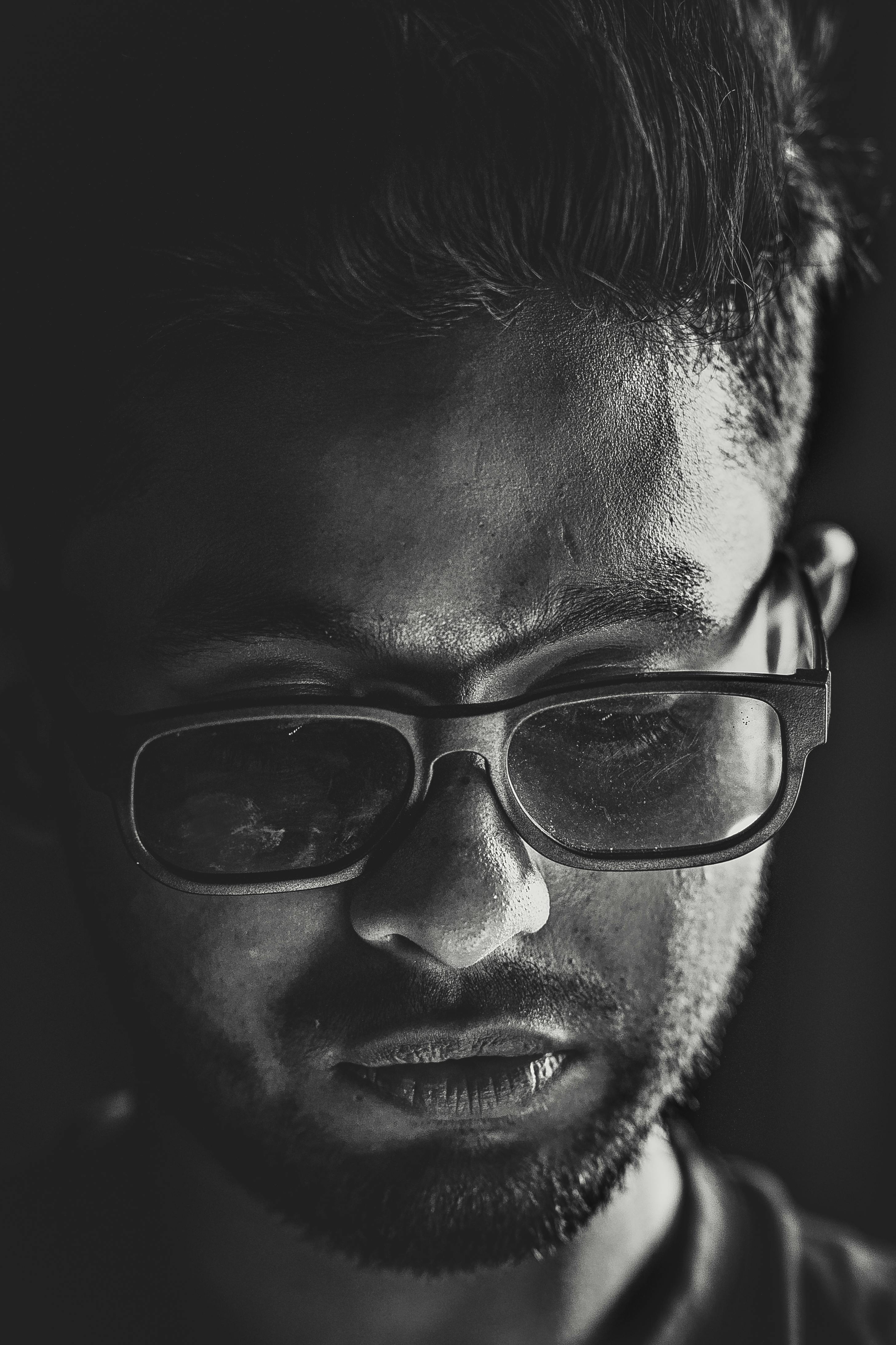 Zadarmo Dramatický čiernobiely detailný portrét zamysleného mladého muža s okuliarmi. Fotka z fotobanky