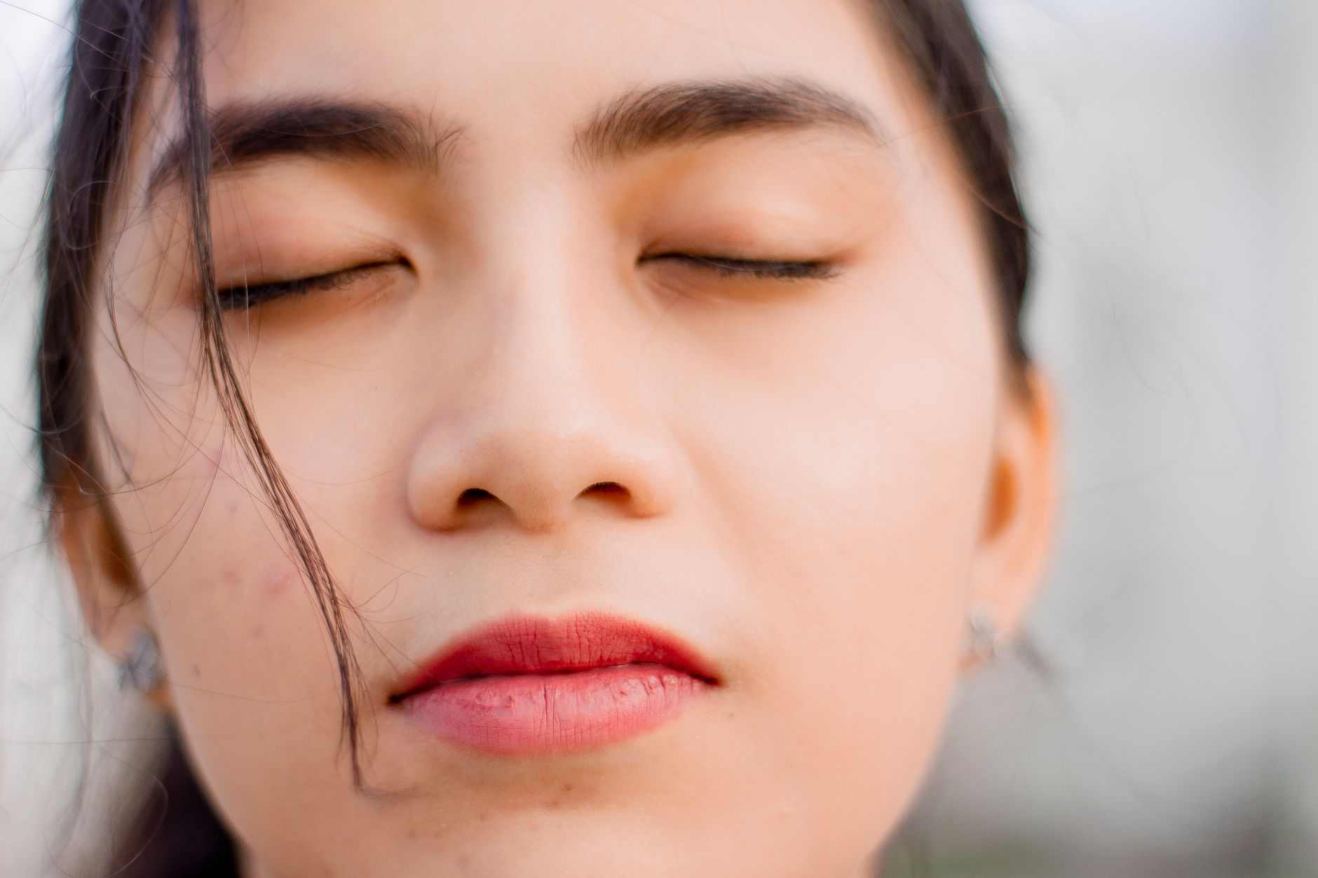 Serene close-up portrait of a woman with closed eyes, embodying calmness and contemplation.