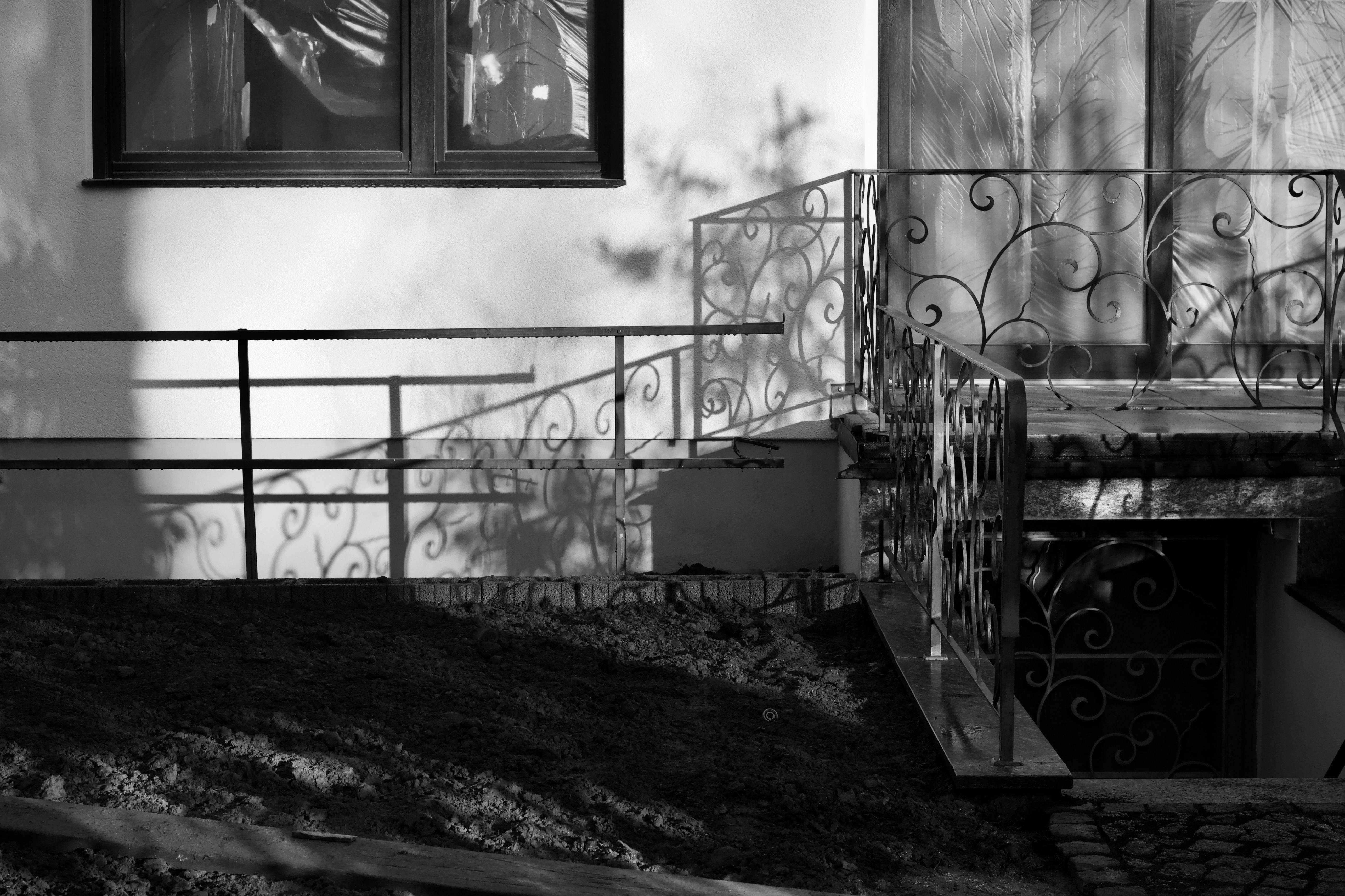 Безкоштовне Художні тіні та візерунки на балконі з декоративними перилами в чорно-білому кольорі. стокове фото