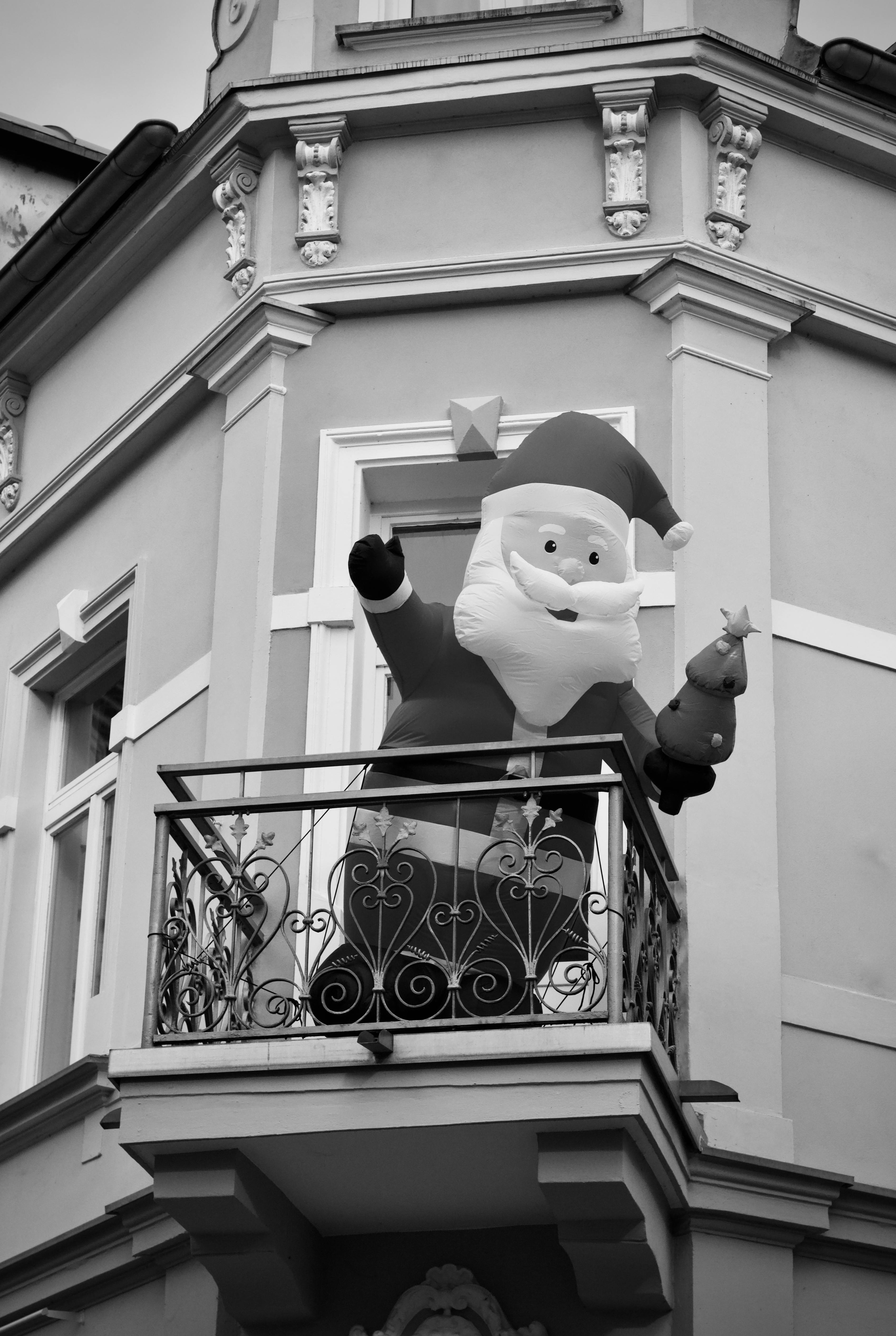 Zadarmo Slávnostný čiernobiely obrázok nafukovacieho Santa Clausa na balkóne budovy. Fotka z fotobanky